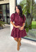 Rich in color and timeless in style, this burgundy dress is the perfect piece to carry you through the fall season. Designed with a classic button-front silhouette, this effortlessly feminine dress features charming puff sleeves and a matching self-tie belt that cinches the waist for a flattering, customizable fit. Side pockets add everyday functionality, while the fully lined cotton fabric keeps you comfortable from morning to night. 