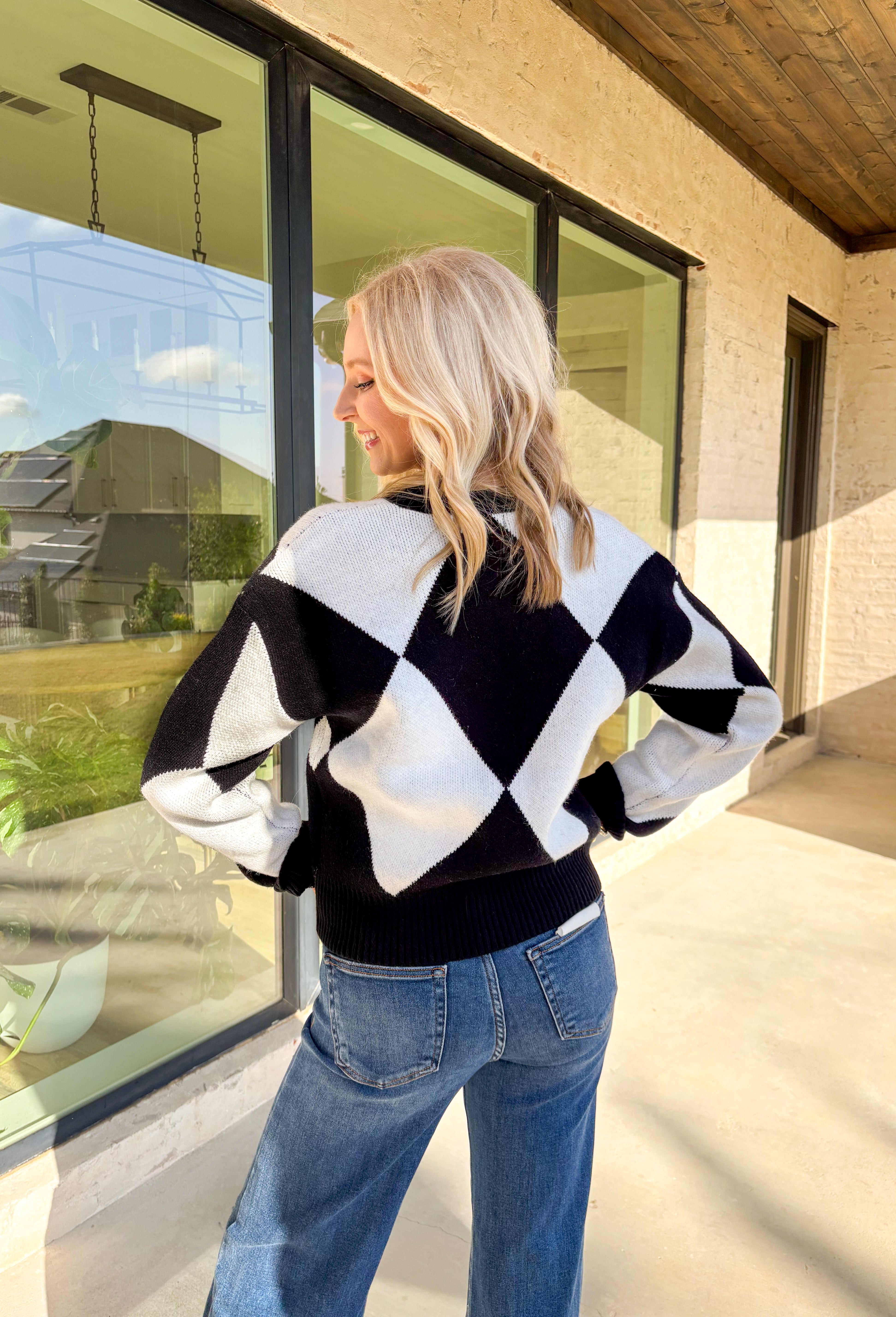 Classic with a cozy twist—this black and white argyle cardigan by On Twelfth is a timeless piece you’ll reach for again and again. The gold textured buttons add a touch of polish, while the soft knit fabric keeps it warm and comfortable for the season. Whether you dress it up or keep it casual, this cardigan brings effortless style to any outfit.