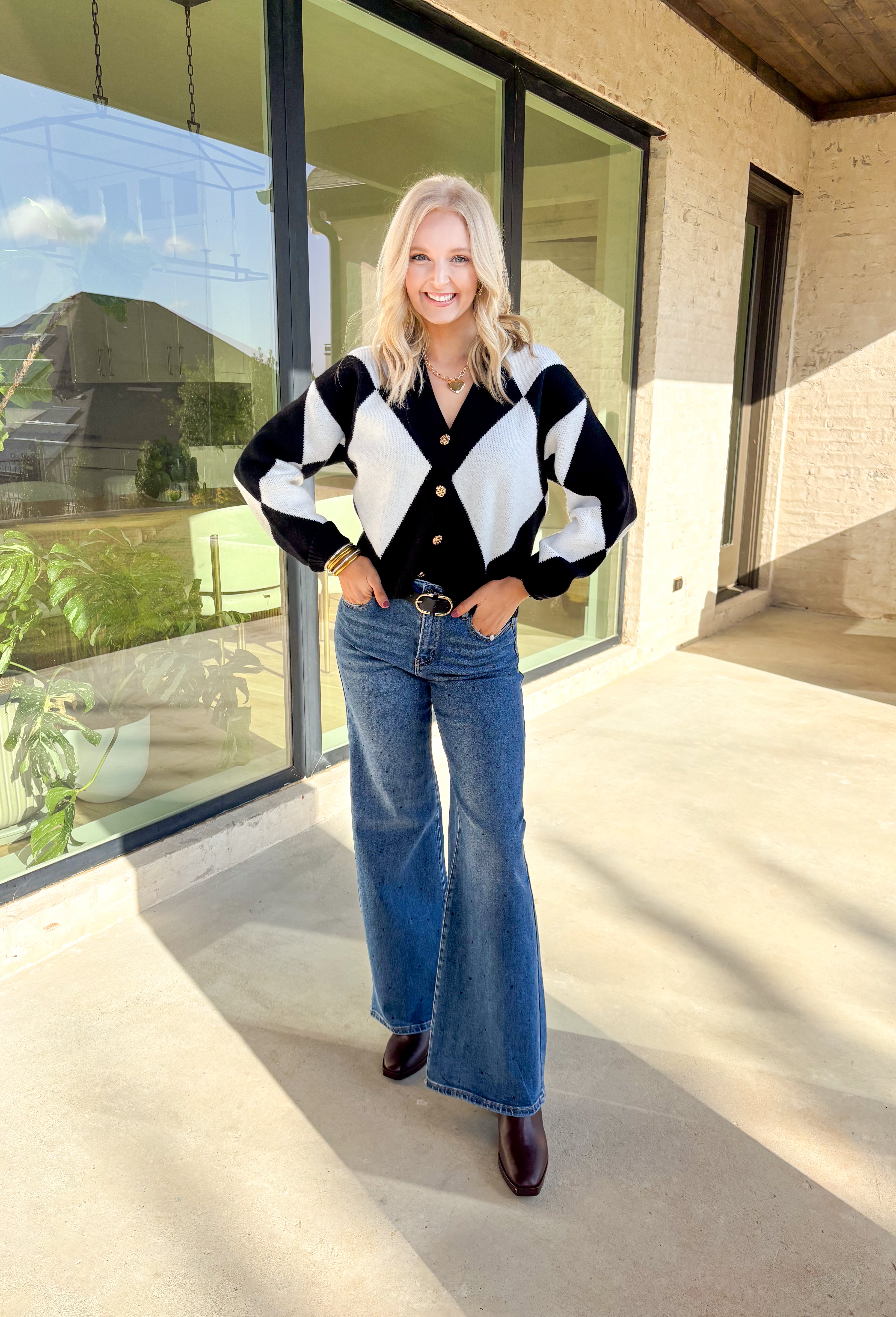 Classic with a cozy twist—this black and white argyle cardigan by On Twelfth is a timeless piece you’ll reach for again and again. The gold textured buttons add a touch of polish, while the soft knit fabric keeps it warm and comfortable for the season. Whether you dress it up or keep it casual, this cardigan brings effortless style to any outfit.