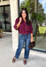 Every wardrobe needs a timeless wine blouse, and this versatile top from Entro is one you'll reach for again and again. Designed with a flattering v-neckline and button-front closure, this effortlessly polished piece transitions seamlessly from workdays to weekends. The ¾ roll-tab sleeves offer versatile styling, while the elasticized smocked back hem creates a comfortable fit with a modern touch. 