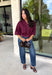 Every wardrobe needs a timeless wine blouse, and this versatile top from Entro is one you'll reach for again and again. Designed with a flattering v-neckline and button-front closure, this effortlessly polished piece transitions seamlessly from workdays to weekends. The ¾ roll-tab sleeves offer versatile styling, while the elasticized smocked back hem creates a comfortable fit with a modern touch. 