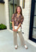 Bring a touch of timeless charm to your fall wardrobe with this beautifully detailed floral blouse. Designed in a warm brown hue with a soft neutral floral print, this top is the perfect blend of feminine and effortless. Delicate pintuck detailing, a flattering v-neckline, and button-front accents create a polished look, while the puff sleeves with smocked ruffle cuffs add just the right amount of romantic flair. 