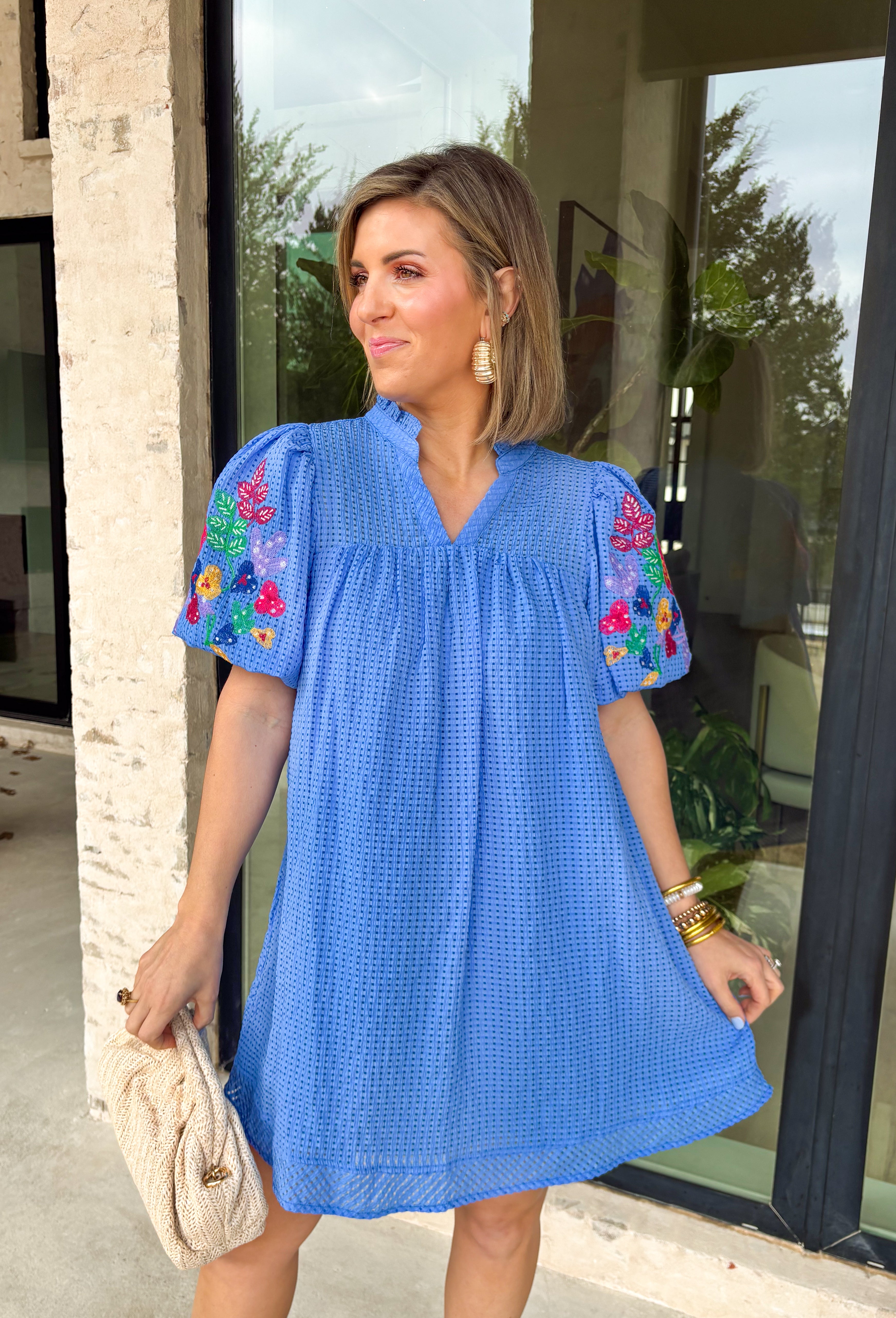 Fresh, playful, and full of spring charm, this blue textured gingham dress by Umgee is a total standout. The subtle mini gingham pattern gives it a classic feel, while the colorful floral embroidery on the puff sleeves adds a fun, eye-catching touch. Finished with a soft ruffle v-neckline and a fully lined interior, this dress feels just as good as it looks—perfect for sunny days, brunch plans, or spring events.