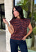 Bring a bold touch to your fall wardrobe with this effortlessly chic knit sweater. The camel and black zebra print offers a fresh take on animal print, while the mock neckline and sleeveless silhouette make it perfect for layering under jackets and cardigans or wearing on its own during those warm autumn afternoons. Soft, comfortable, and endlessly versatile, this is a piece you'll reach for again and again all season long.