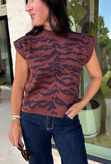 Bring a bold touch to your fall wardrobe with this effortlessly chic knit sweater. The camel and black zebra print offers a fresh take on animal print, while the mock neckline and sleeveless silhouette make it perfect for layering under jackets and cardigans or wearing on its own during those warm autumn afternoons. Soft, comfortable, and endlessly versatile, this is a piece you'll reach for again and again all season long.