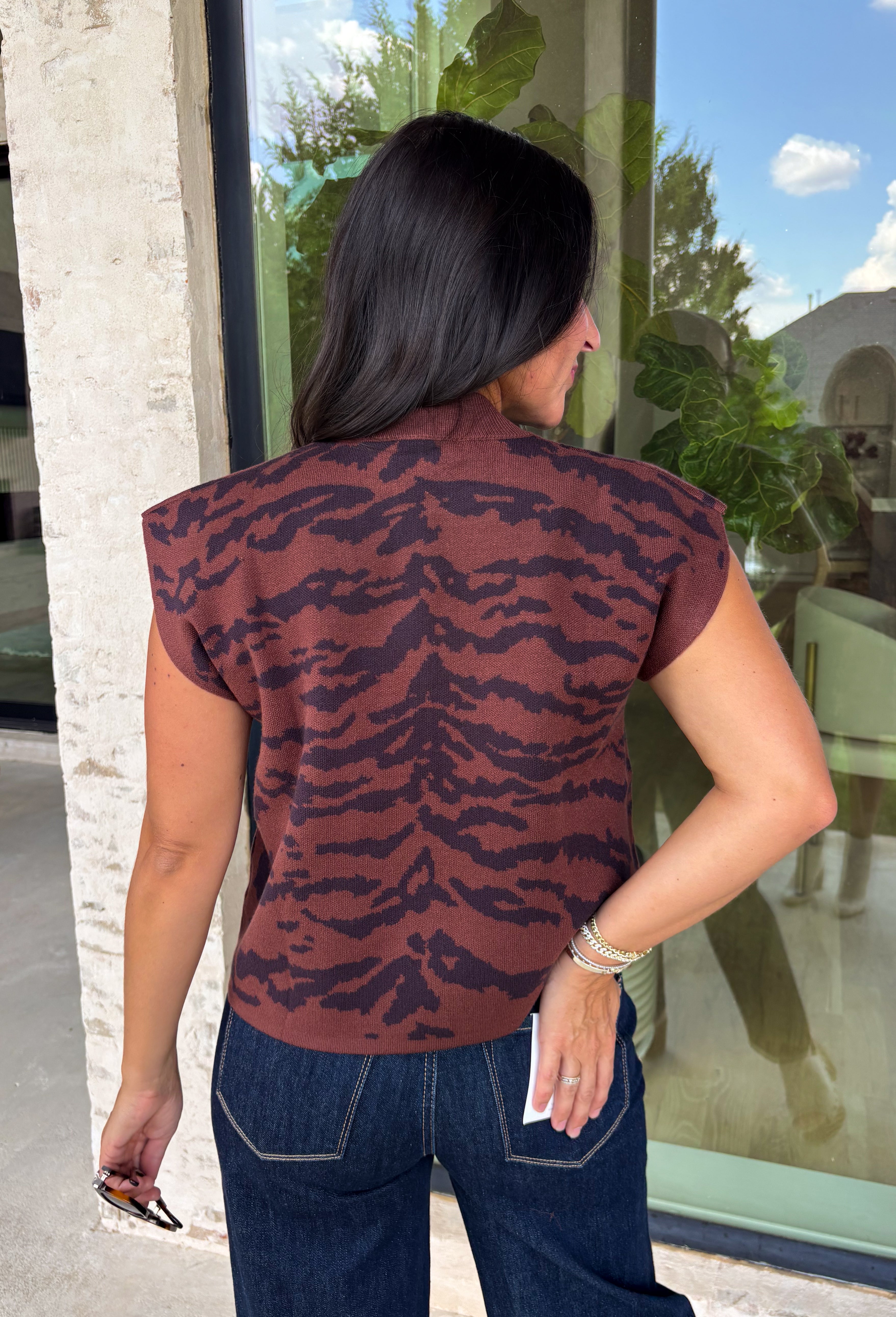 Bring a bold touch to your fall wardrobe with this effortlessly chic knit sweater. The camel and black zebra print offers a fresh take on animal print, while the mock neckline and sleeveless silhouette make it perfect for layering under jackets and cardigans or wearing on its own during those warm autumn afternoons. Soft, comfortable, and endlessly versatile, this is a piece you'll reach for again and again all season long.