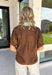 Rich fall colors and timeless details make this brown top an instant wardrobe favorite! The rich brown hue is beautifully accented with a blue trim along the neckline and front, creating a subtle pop of color that feels both feminine and sophisticated. The elastic puff sleeves add just the right amount of volume, giving this top an elevated look that's perfect for workdays, dinner dates, or weekend outings. Comfortable and easy to style, it's the kind of piece you'll reach for all season long. 