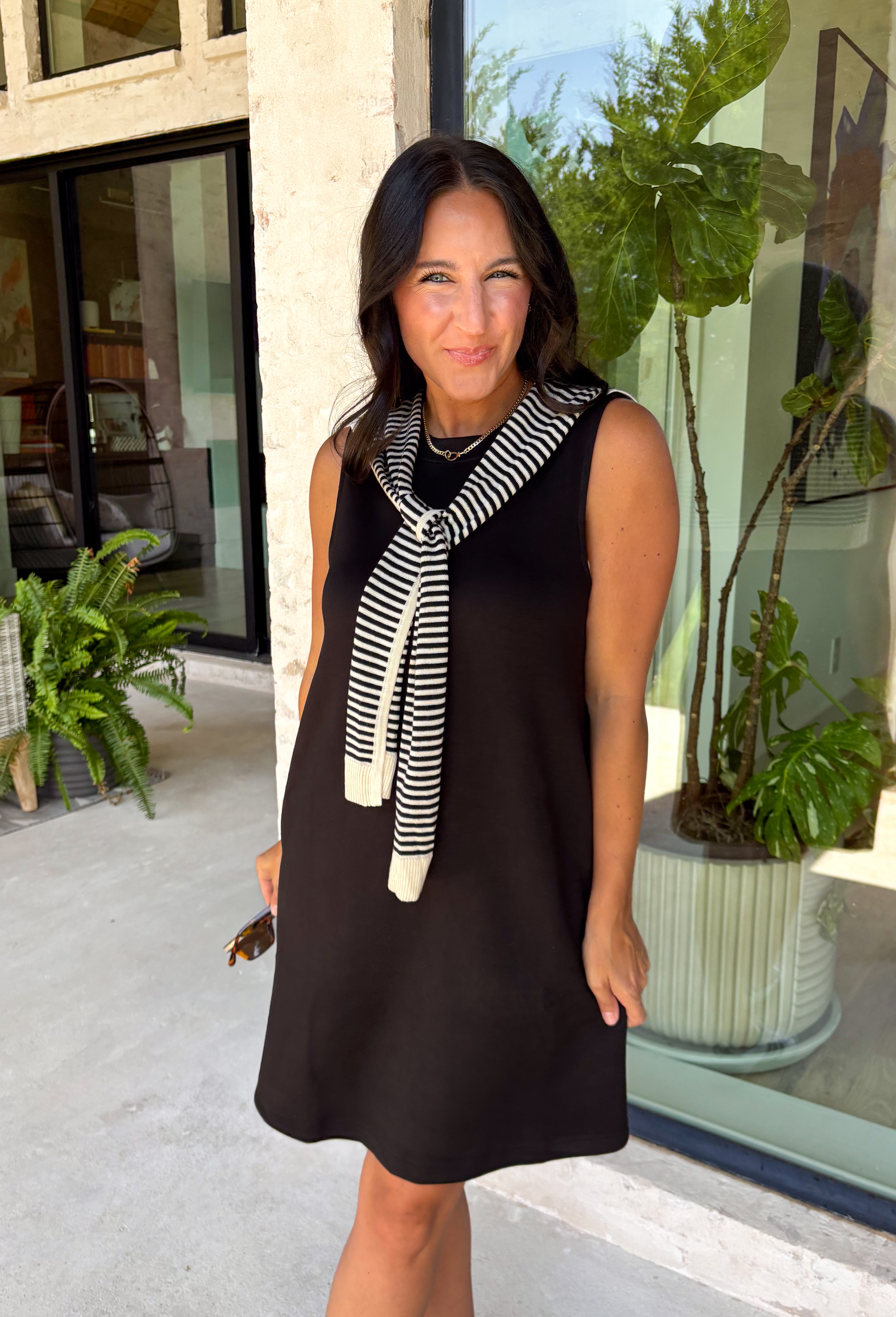 The layered look has never been easier! This black knit mini dress features an attached black and white striped sweater scarf detail, giving you the cozy, elevated style of layered fall fashion in one effortless piece. Crafted from a soft, comfortable knit, it's perfect for crisp autumn days when you want to look polished without sacrificing comfort. From brunch dates and shopping trips to dinner with friends, this chic dress is ready for every fall occasion.