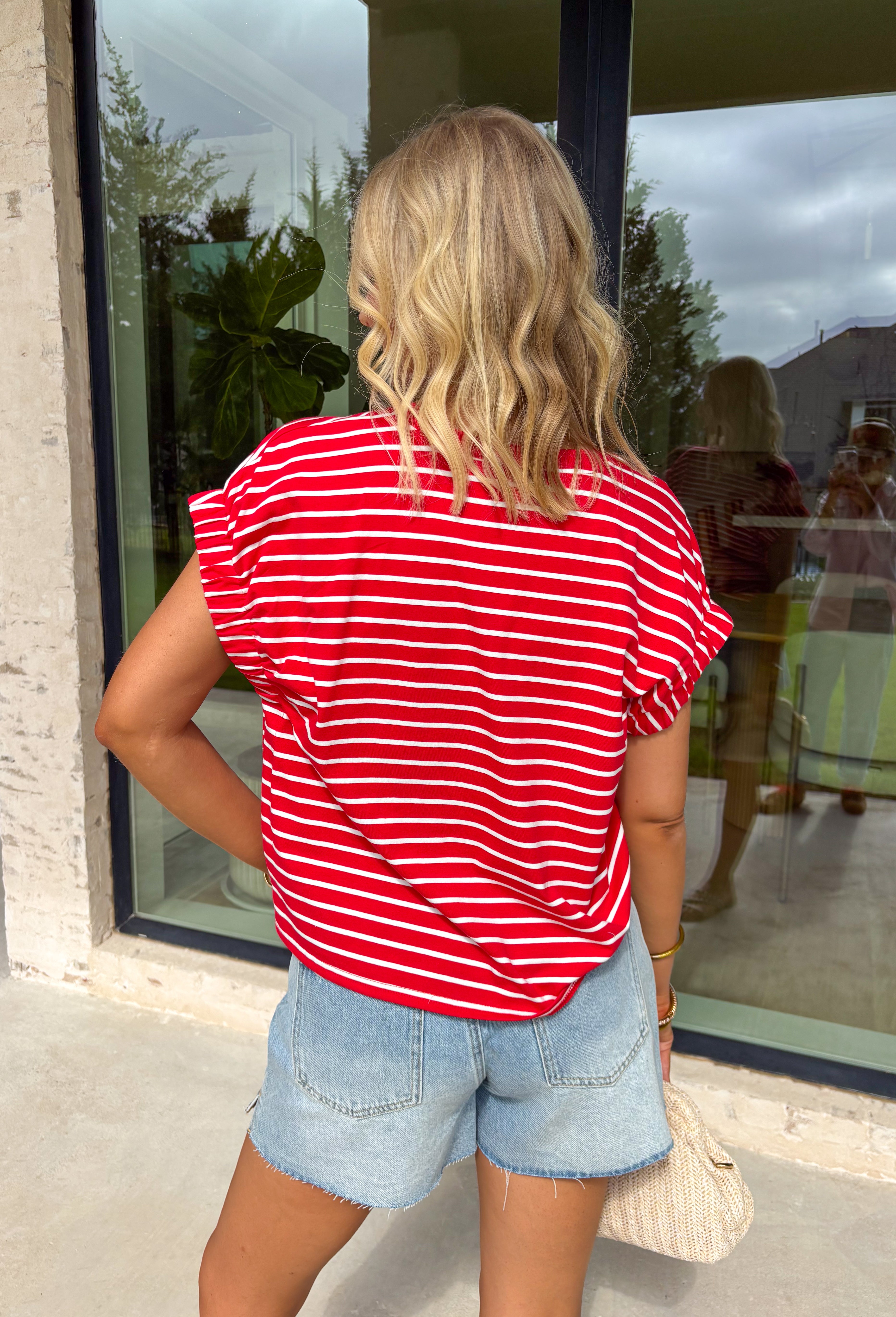 Nothing says “easy spring outfit” like a classic red-and-white stripe moment! This short sleeve top is one of those throw-on-and-go pieces that instantly looks cute without even trying. The bright red base feels fun and fresh for the season, while the crisp white stripes keep it timeless. Finished with elastic sleeve cuffs for a soft, slightly puffed shape, it’s comfy enough for all-day wear and polished enough to dress up with your favorite denim and accessories.