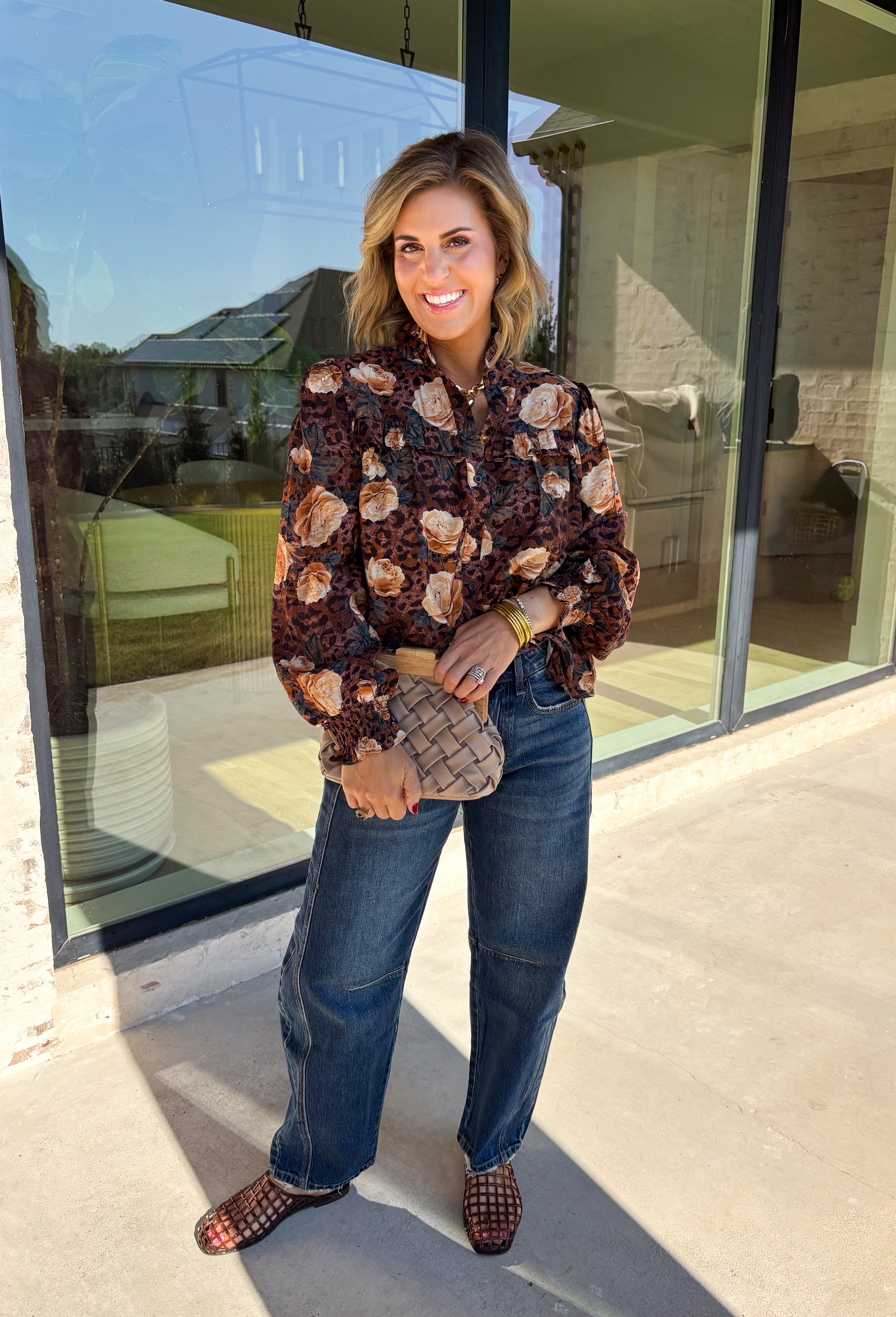 Bring a fresh twist to your fall wardrobe with this beautifully detailed blouse from Fate. Featuring a rich brown leopard-inspired print accented with a soft neutral floral design, this feminine top effortlessly blends bold style with timeless charm. The button-front silhouette is finished with a subtle ruffle neckline and delicate ruffle details throughout the front and back for added texture. 