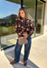 Bring a fresh twist to your fall wardrobe with this beautifully detailed blouse from Fate. Featuring a rich brown leopard-inspired print accented with a soft neutral floral design, this feminine top effortlessly blends bold style with timeless charm. The button-front silhouette is finished with a subtle ruffle neckline and delicate ruffle details throughout the front and back for added texture. 