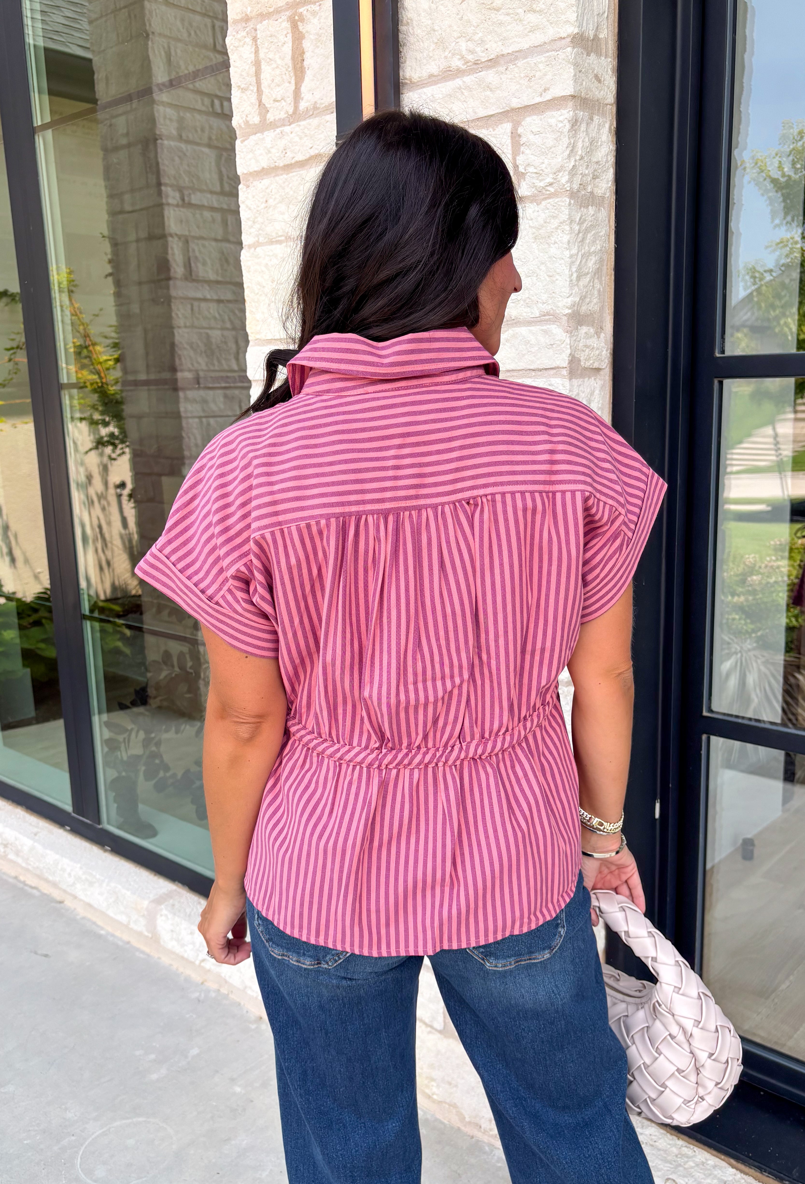 Classic stripes get a flattering update with this effortlessly stylish top that's perfect for the season! Designed in a rich marsala hue with timeless stripe detailing, this lightweight blouse is easy to dress up or down for wherever your day takes you. The adjustable drawstring waist and gathered back create a figure-flattering silhouette, while the button-front design adds a polished finish. 