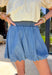 Easy, flirty, and made for sunny spring days, this denim bubble skirt by Doe and Rae is the perfect warm-weather staple. The lightweight denim feel keeps it soft and breathable, while the smocked waistband gives you a comfy, flexible fit that’s easy to wear all day long. Finished with a bubble hem for a fun, feminine shape, this skirt pairs perfectly with everything from fitted tanks to breezy blouses—and it’s basically made for patio season.