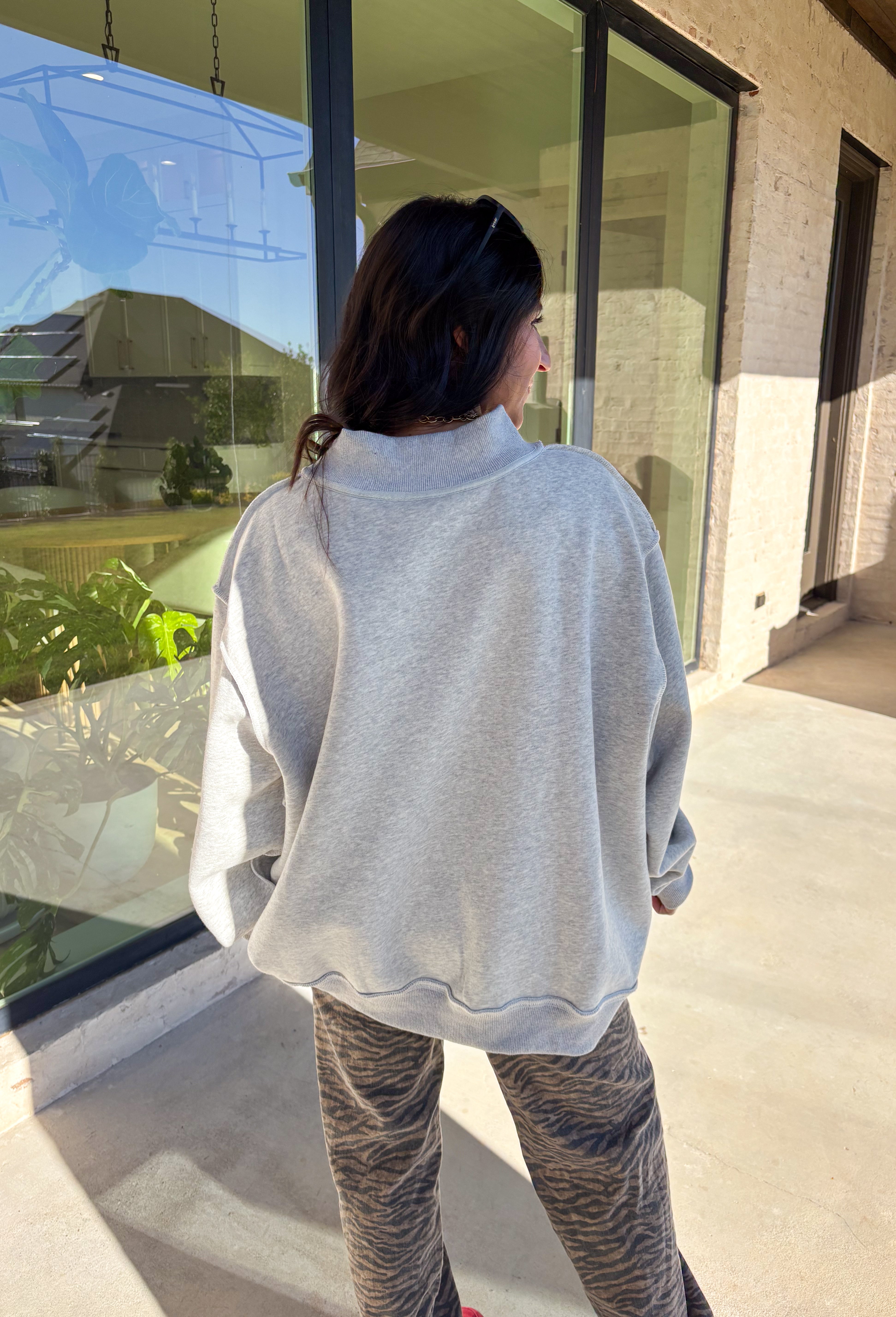 Show your Lone Star pride in this cozy reversible pullover by Bucket List! Crafted from soft fleece, this heather gray mock neck sweatshirt offers two fun looks in one—one side reads “Texas” in bold black lettering, while the reverse features “TX” in bright hot pink. Warm, comfy, and effortlessly cool, it’s perfect for everything from game days to laid-back weekends.