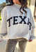 Show your Lone Star pride in this cozy reversible pullover by Bucket List! Crafted from soft fleece, this heather gray mock neck sweatshirt offers two fun looks in one—one side reads “Texas” in bold black lettering, while the reverse features “TX” in bright hot pink. Warm, comfy, and effortlessly cool, it’s perfect for everything from game days to laid-back weekends.