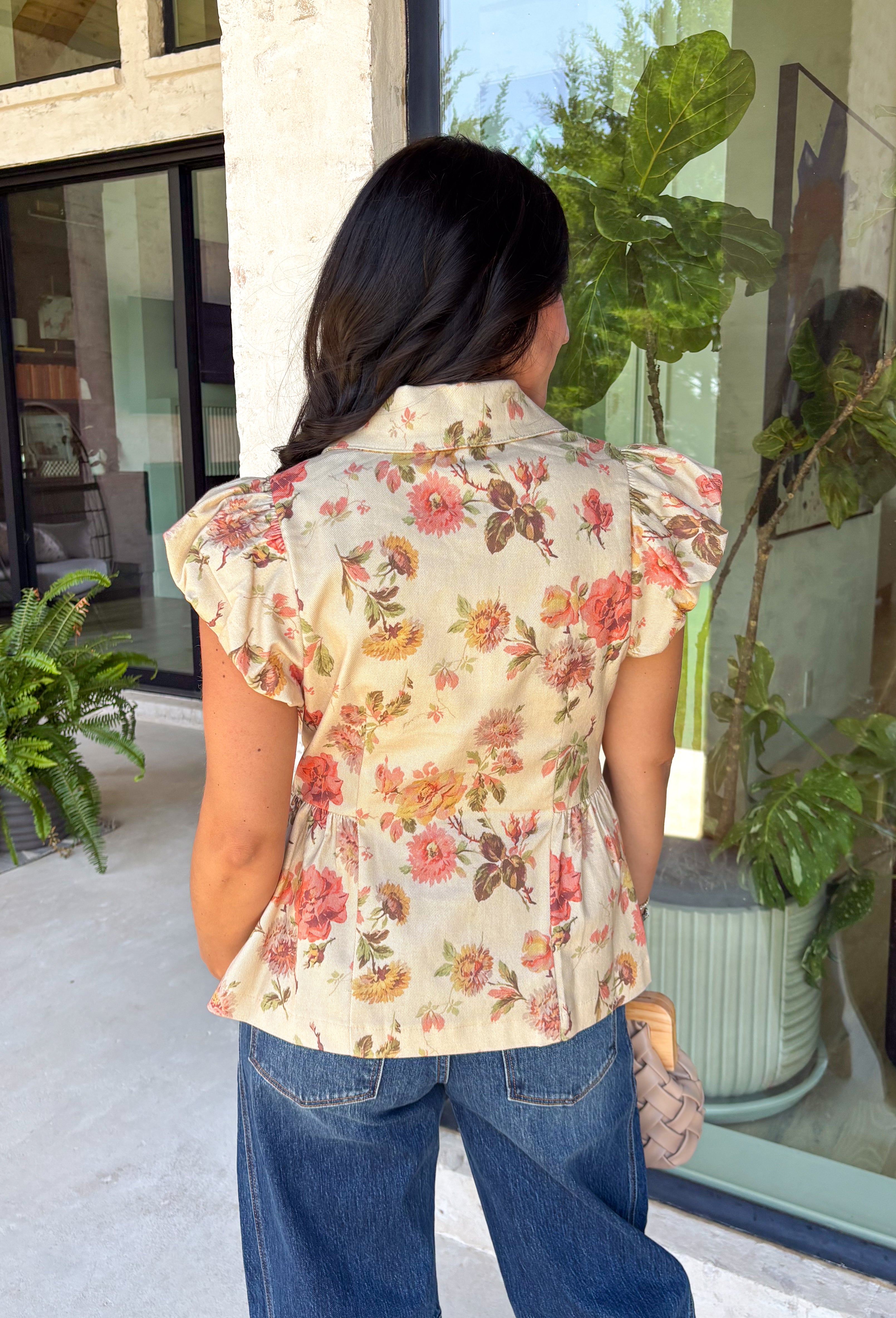 Fresh florals meet cozy fall style in this charming peplum blouse. Featuring a soft neutral backdrop with delicate pops of pink and green, this top brings just the right amount of color to your autumn wardrobe. The collared neckline and button front add a timeless, polished touch, while the peplum hem creates a flattering silhouette you'll love. Elastic puff sleeves complete the look with feminine charm, making this top perfect for everything from workdays to weekend brunches.