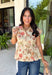 Fresh florals meet cozy fall style in this charming peplum blouse. Featuring a soft neutral backdrop with delicate pops of pink and green, this top brings just the right amount of color to your autumn wardrobe. The collared neckline and button front add a timeless, polished touch, while the peplum hem creates a flattering silhouette you'll love. Elastic puff sleeves complete the look with feminine charm, making this top perfect for everything from workdays to weekend brunches.