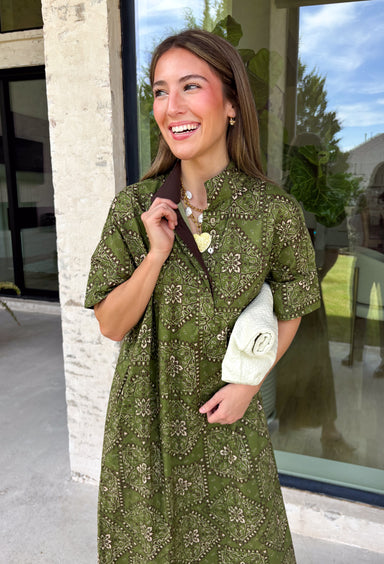 Embrace effortless fall style with this beautifully detailed midi dress from Entro. Designed in a rich olive hue with a vintage-inspired paisley print in shades of brown and off-white, this timeless dress brings the perfect blend of western charm and boho flair. The flattering midi silhouette is easy to dress up or down, while convenient side pockets add an everyday touch you'll love. 