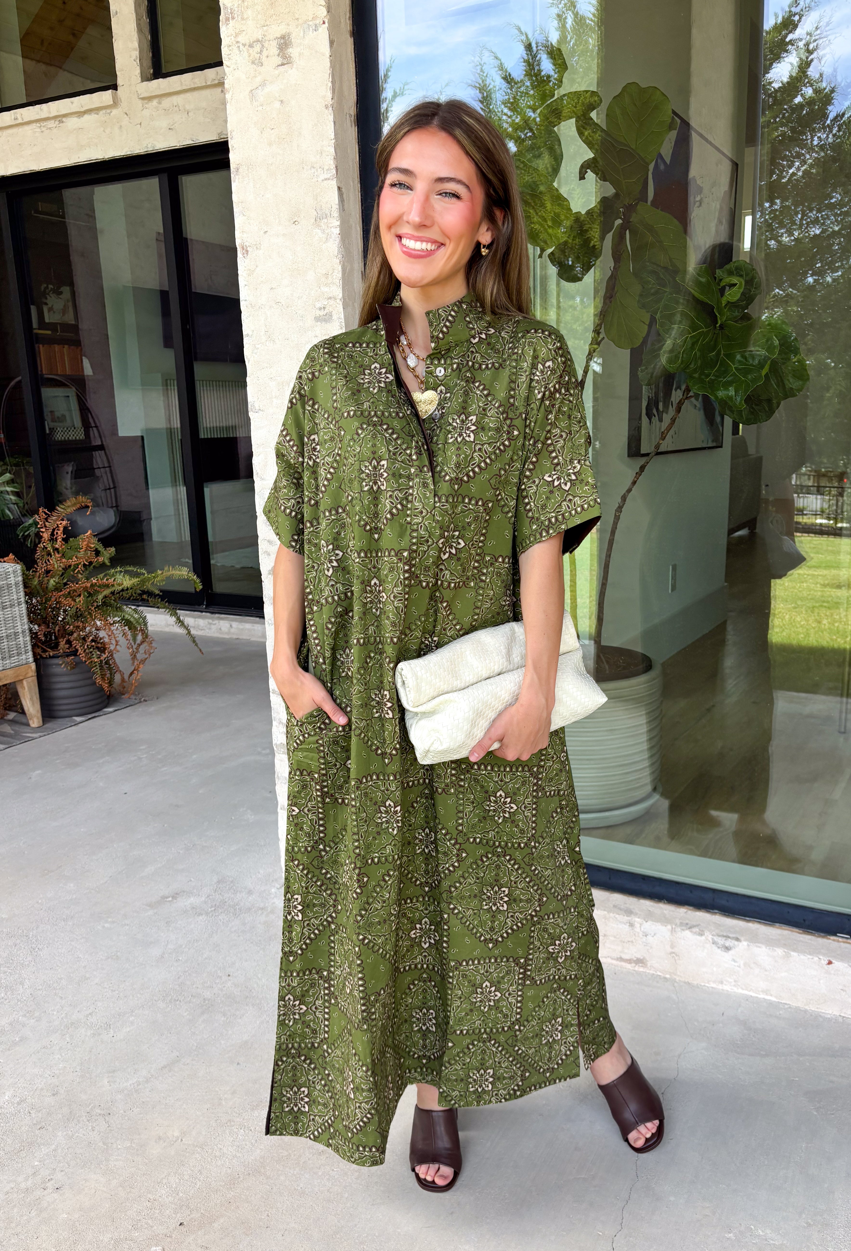 Embrace effortless fall style with this beautifully detailed midi dress from Entro. Designed in a rich olive hue with a vintage-inspired paisley print in shades of brown and off-white, this timeless dress brings the perfect blend of western charm and boho flair. The flattering midi silhouette is easy to dress up or down, while convenient side pockets add an everyday touch you'll love. 