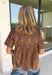 Elevate your fall wardrobe with this stunning faux leather top that perfectly blends edgy style with feminine charm. Designed in a rich chocolate brown, this statement piece features beautiful lace detailing along the front that softens the sleek faux leather finish for a look that's effortlessly sophisticated. The textured fabric adds depth and dimension, while the classic short sleeve silhouette makes it easy to style from season to season. 