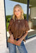 Elevate your fall wardrobe with this stunning faux leather top that perfectly blends edgy style with feminine charm. Designed in a rich chocolate brown, this statement piece features beautiful lace detailing along the front that softens the sleek faux leather finish for a look that's effortlessly sophisticated. The textured fabric adds depth and dimension, while the classic short sleeve silhouette makes it easy to style from season to season. 