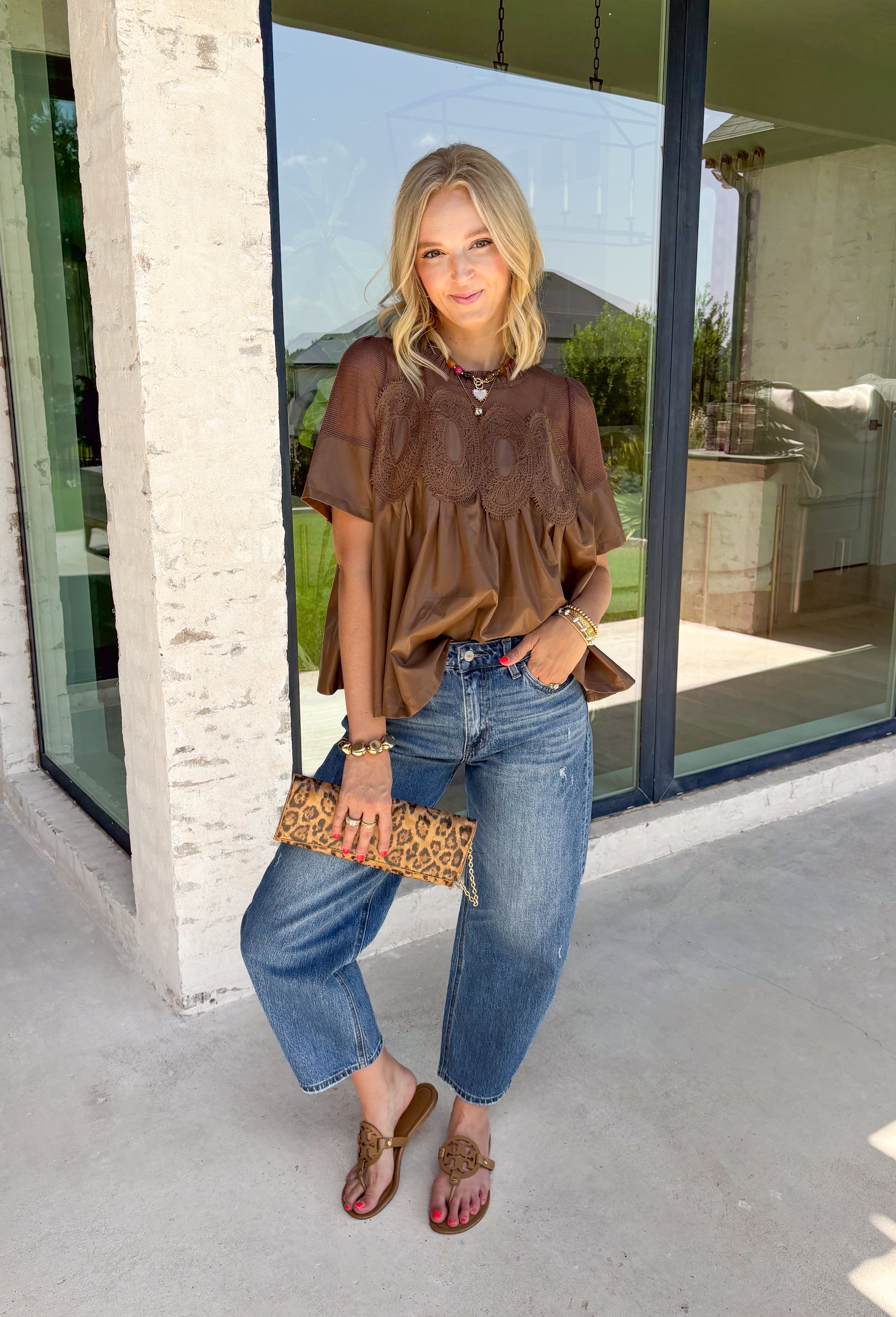Elevate your fall wardrobe with this stunning faux leather top that perfectly blends edgy style with feminine charm. Designed in a rich chocolate brown, this statement piece features beautiful lace detailing along the front that softens the sleek faux leather finish for a look that's effortlessly sophisticated. The textured fabric adds depth and dimension, while the classic short sleeve silhouette makes it easy to style from season to season. 