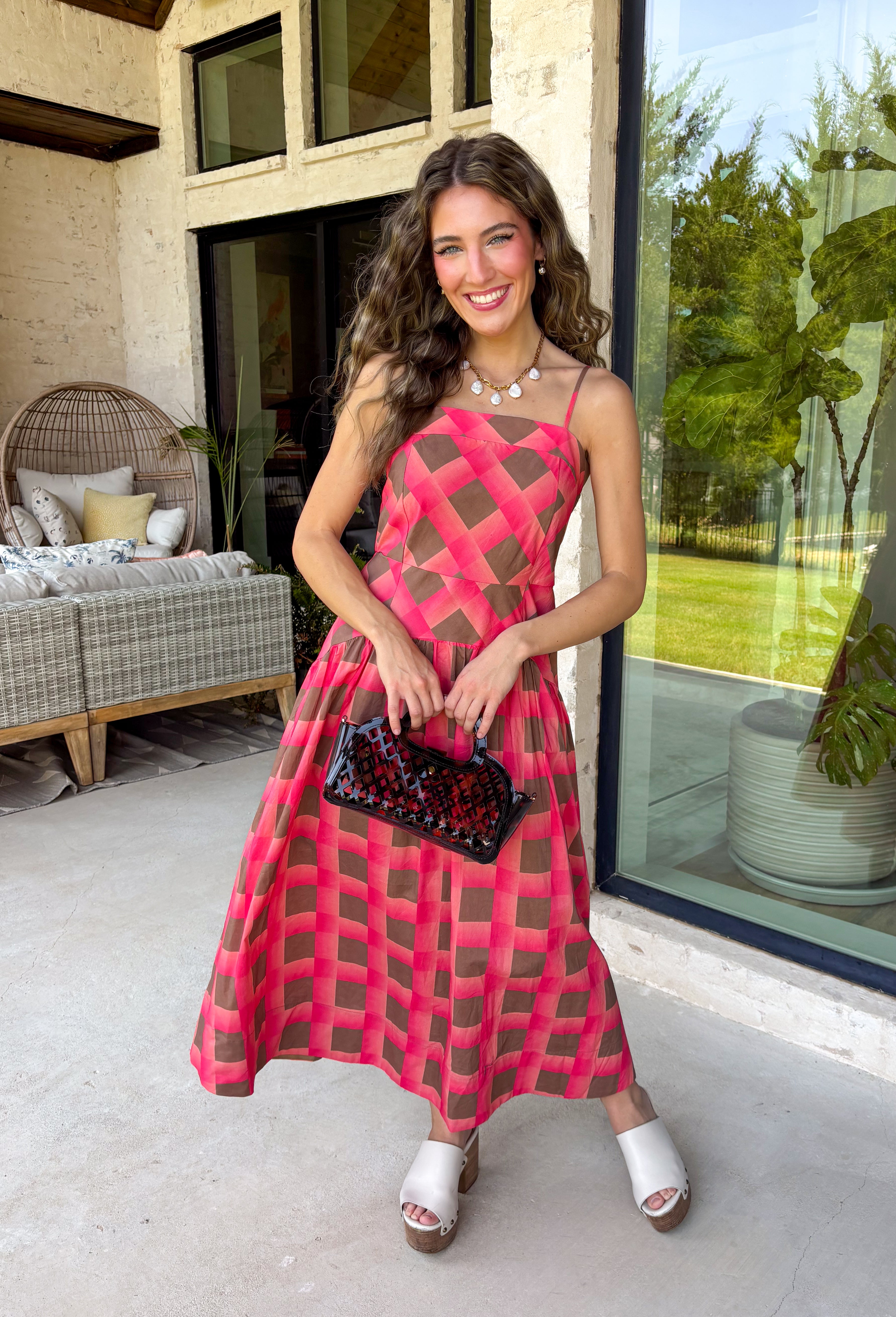 Bring warm seasonal charm to your wardrobe with this beautifully crafted plaid midi dress. Featuring a lovely coral and brown plaid print, this timeless style is designed with a flattering straight neckline and a flowing midi silhouette that's perfect for every fall occasion. Adjustable shoulder straps and a smocked back provide a comfortable, customizable fit, while the fully lined design offers effortless wear from day to night. 