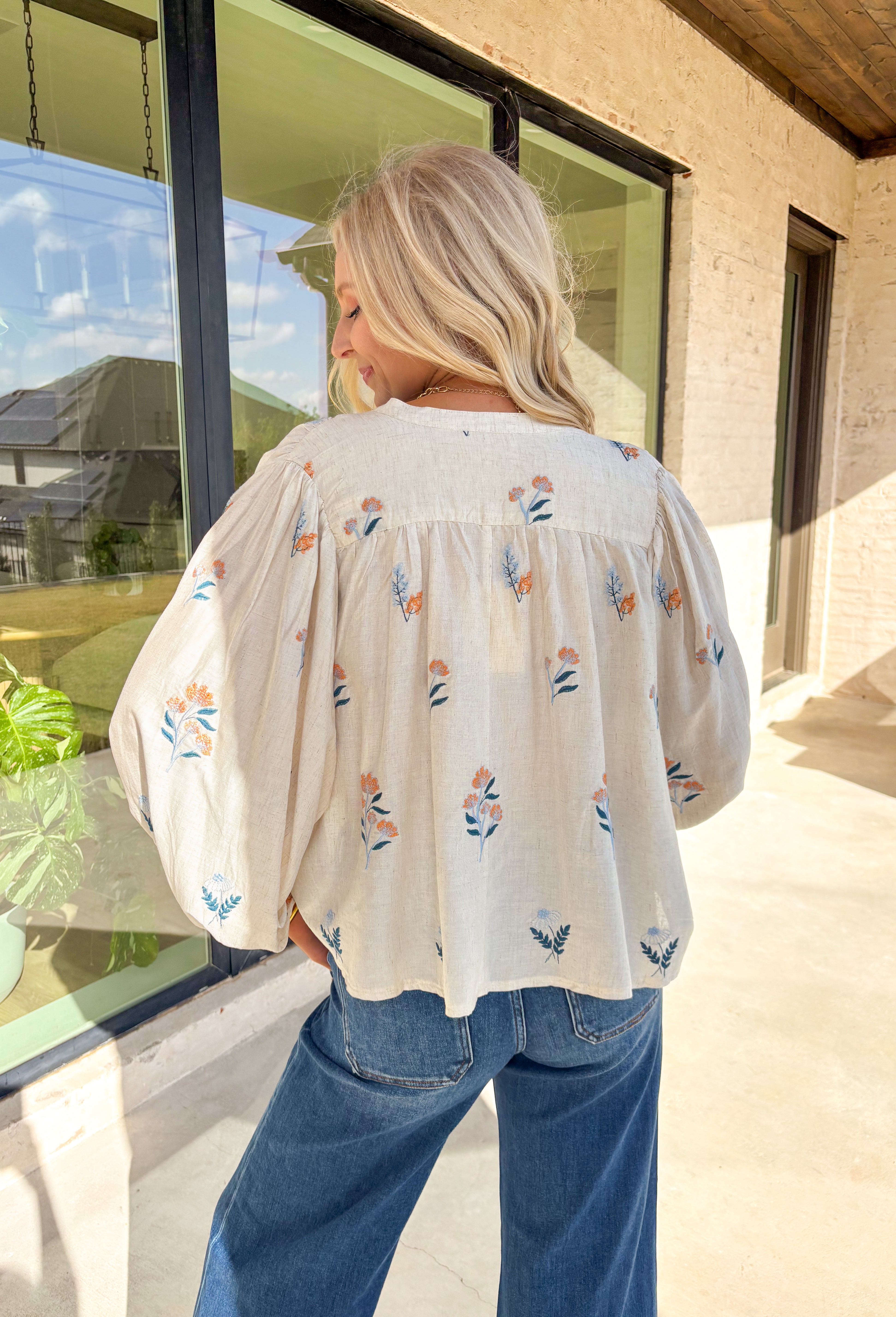 Welcome the season in style with this beautifully embroidered ecru top by Entro. Featuring intricate floral embroidery in shades of blue, navy, and mustard, this breezy blouse adds a soft, cheerful touch to your spring wardrobe. The relaxed fit and balloon sleeves create a flowy, flattering silhouette—perfect for warm days and sunny afternoons.