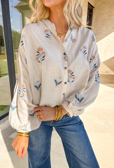 Welcome the season in style with this beautifully embroidered ecru top by Entro. Featuring intricate floral embroidery in shades of blue, navy, and mustard, this breezy blouse adds a soft, cheerful touch to your spring wardrobe. The relaxed fit and balloon sleeves create a flowy, flattering silhouette—perfect for warm days and sunny afternoons.