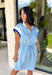 This light blue short sleeve dress is the perfect mix of sporty and cute for summer! Designed with a quarter zip neckline and elastic self-tie waist, it gives you that flattering, adjustable fit while keeping things comfortable for all-day wear. The navy, light blue, and white athletic stripe detail along the front, neckline, and cuffs adds a fun, energetic touch that makes this one stand out. Finished with side pockets (always a win), it’s perfect for everything from errands to casual plans. 
