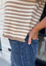 Timeless stripes get a fun seasonal update in this cozy short sleeve sweater. Featuring classic taupe and white stripes with a blue contrast neckline, this knit is the perfect blend of classic and playful. The soft, cozy fabric makes it ideal for crisp fall mornings and cool evenings, while the short sleeves make layering effortless under jackets, and blazers. 