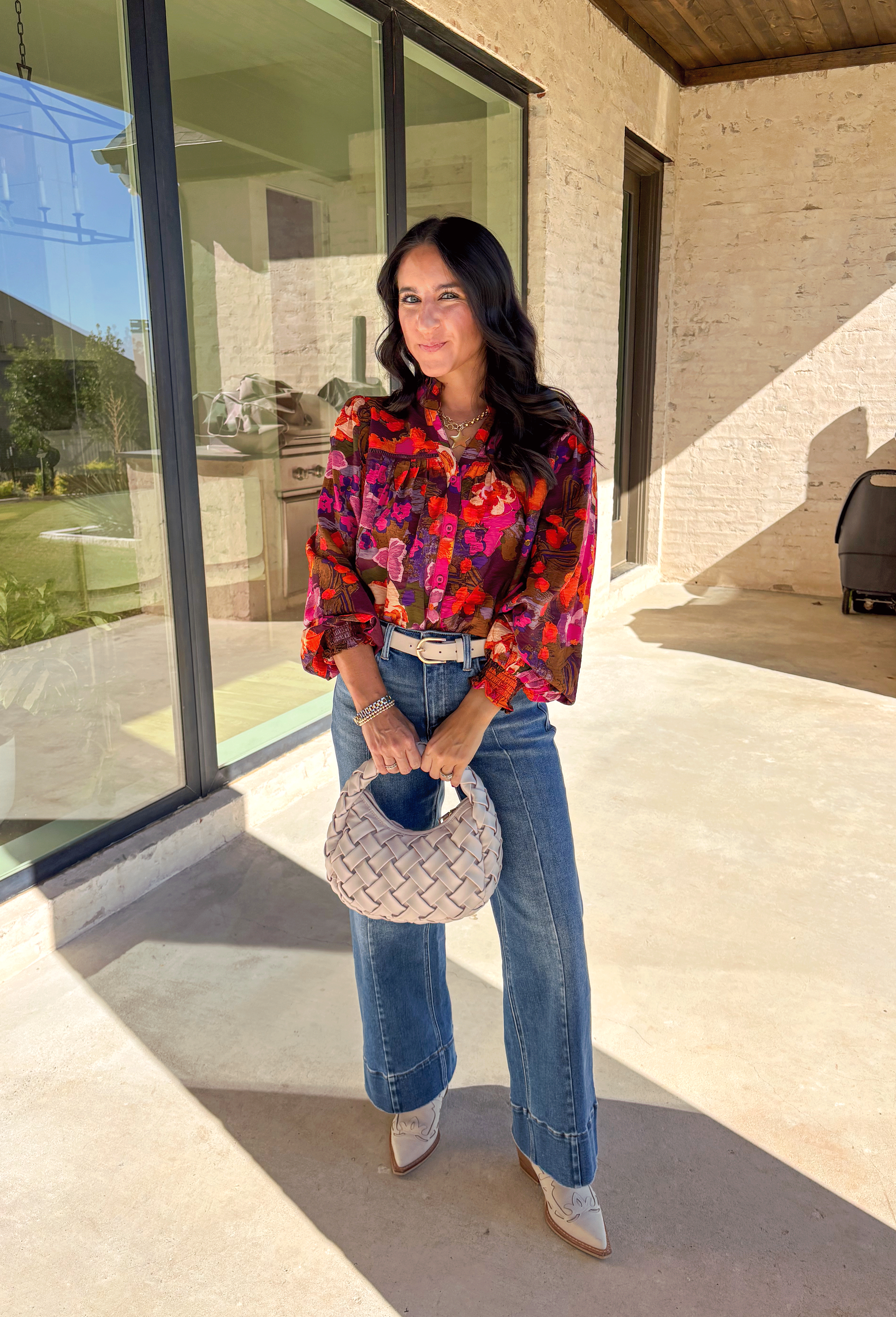 Brighten up your fall wardrobe with this stunning floral print top by Fate. Designed with long sleeves and a subtle ruffle neckline, this piece blends feminine details with bold color. The ladder lace trim across the top adds a touch of texture, while the smocked sleeves bring in a flattering finish. With shades of orange, purple, and pink throughout, this top perfectly balances playful color and everyday sophistication.