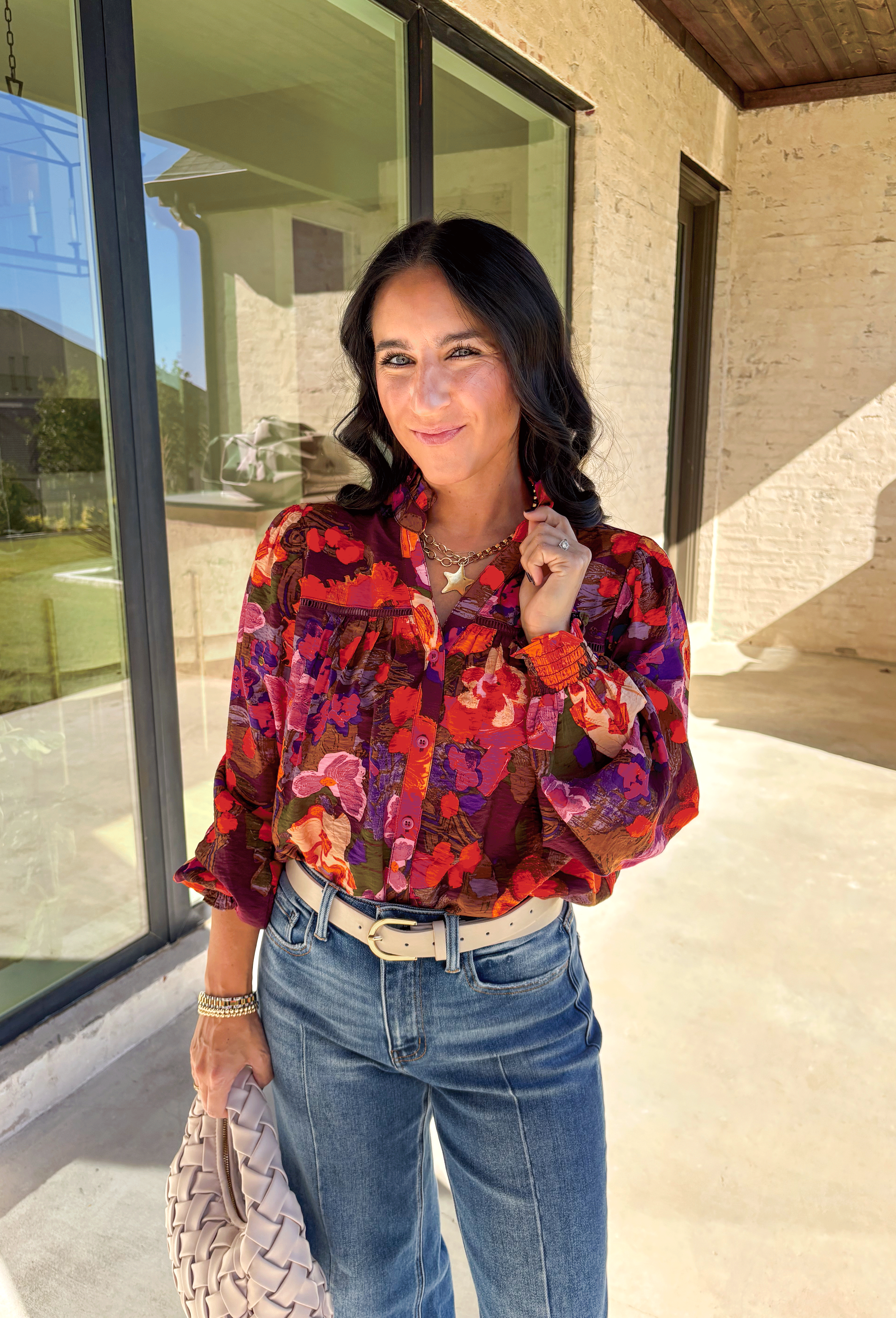 Brighten up your fall wardrobe with this stunning floral print top by Fate. Designed with long sleeves and a subtle ruffle neckline, this piece blends feminine details with bold color. The ladder lace trim across the top adds a touch of texture, while the smocked sleeves bring in a flattering finish. With shades of orange, purple, and pink throughout, this top perfectly balances playful color and everyday sophistication.