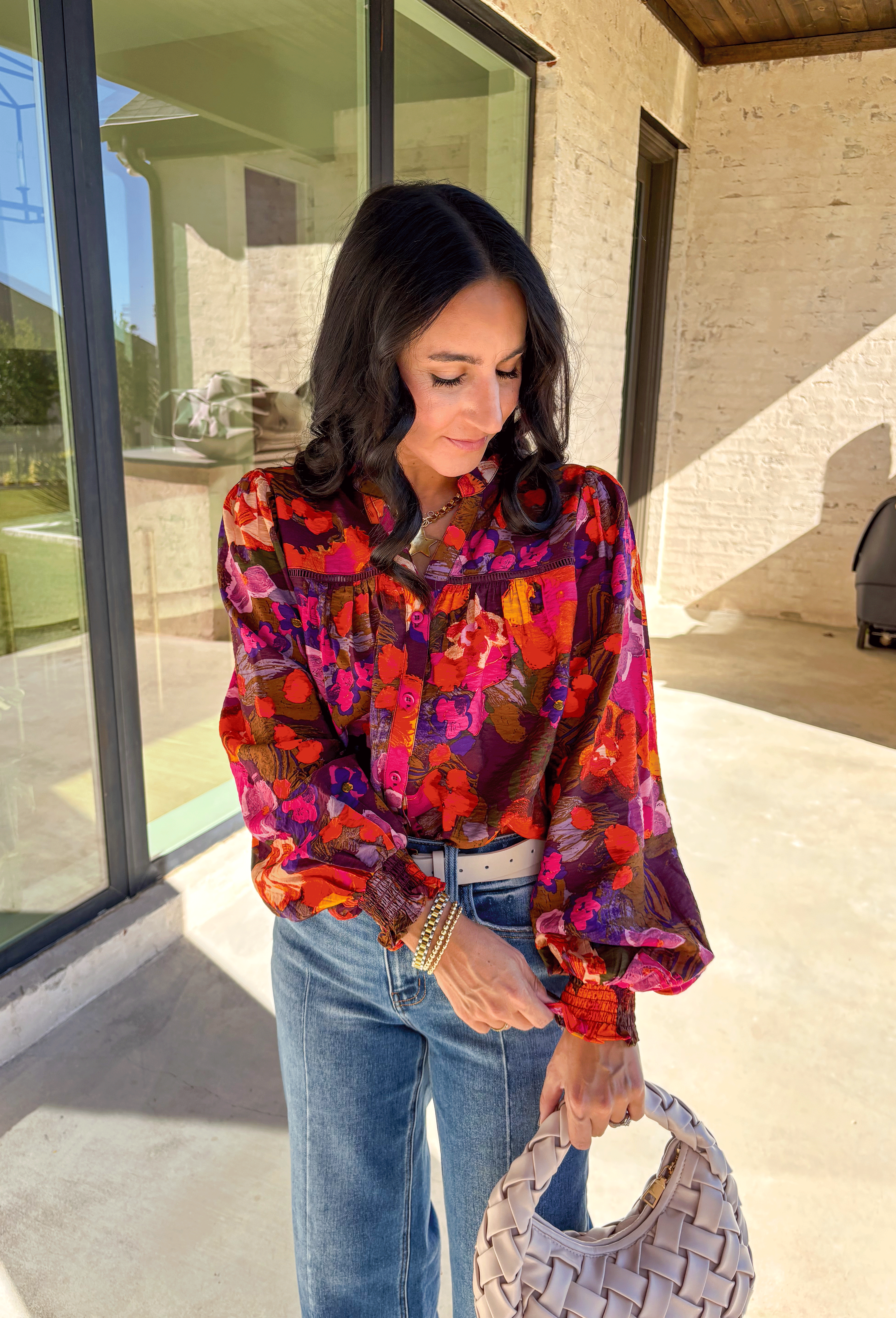 Brighten up your fall wardrobe with this stunning floral print top by Fate. Designed with long sleeves and a subtle ruffle neckline, this piece blends feminine details with bold color. The ladder lace trim across the top adds a touch of texture, while the smocked sleeves bring in a flattering finish. With shades of orange, purple, and pink throughout, this top perfectly balances playful color and everyday sophistication.