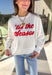 Get in the holiday spirit with this cheerful white pullover by Shiraleah! The front features a textured red “‘Tis The Season” design, while the back adds a playful surprise with a colorful “Fa La La” print. Its soft fabric and cropped fit make it the perfect piece for decking the halls or cozy nights by the fire.