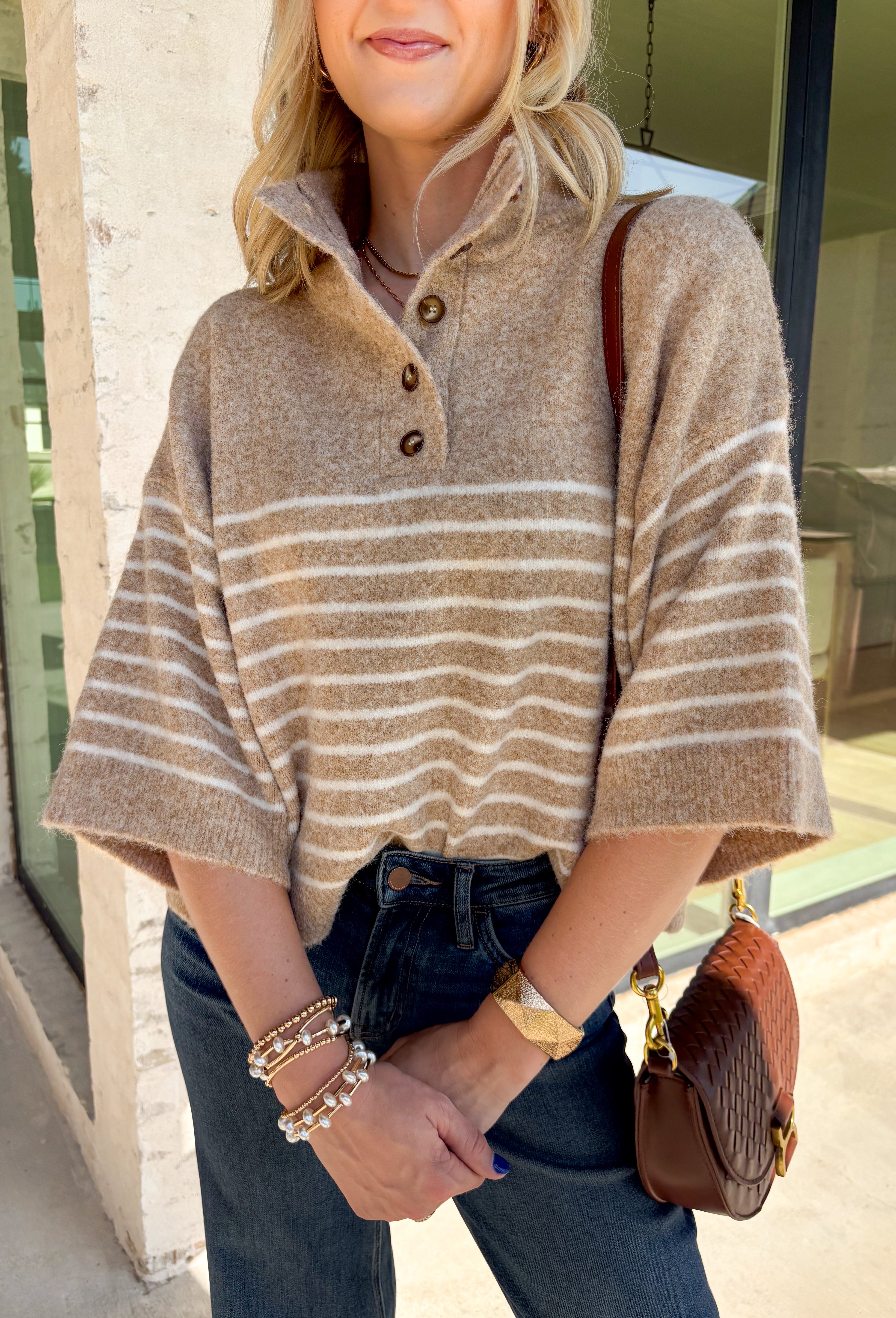 Classic stripes and cozy comfort come together in this effortlessly stylish sweater from Entro. Designed in a warm camel hue with timeless off-white stripes, this short sleeve sweater is the perfect blend of polished and comfortable. The mock neckline gives it a sophisticated touch, while the decorative button detail at the front adds just the right amount of charm. Finished with ribbed trim and a soft, cozy knit, this versatile top is perfect for everything from workdays to weekend coffee dates.