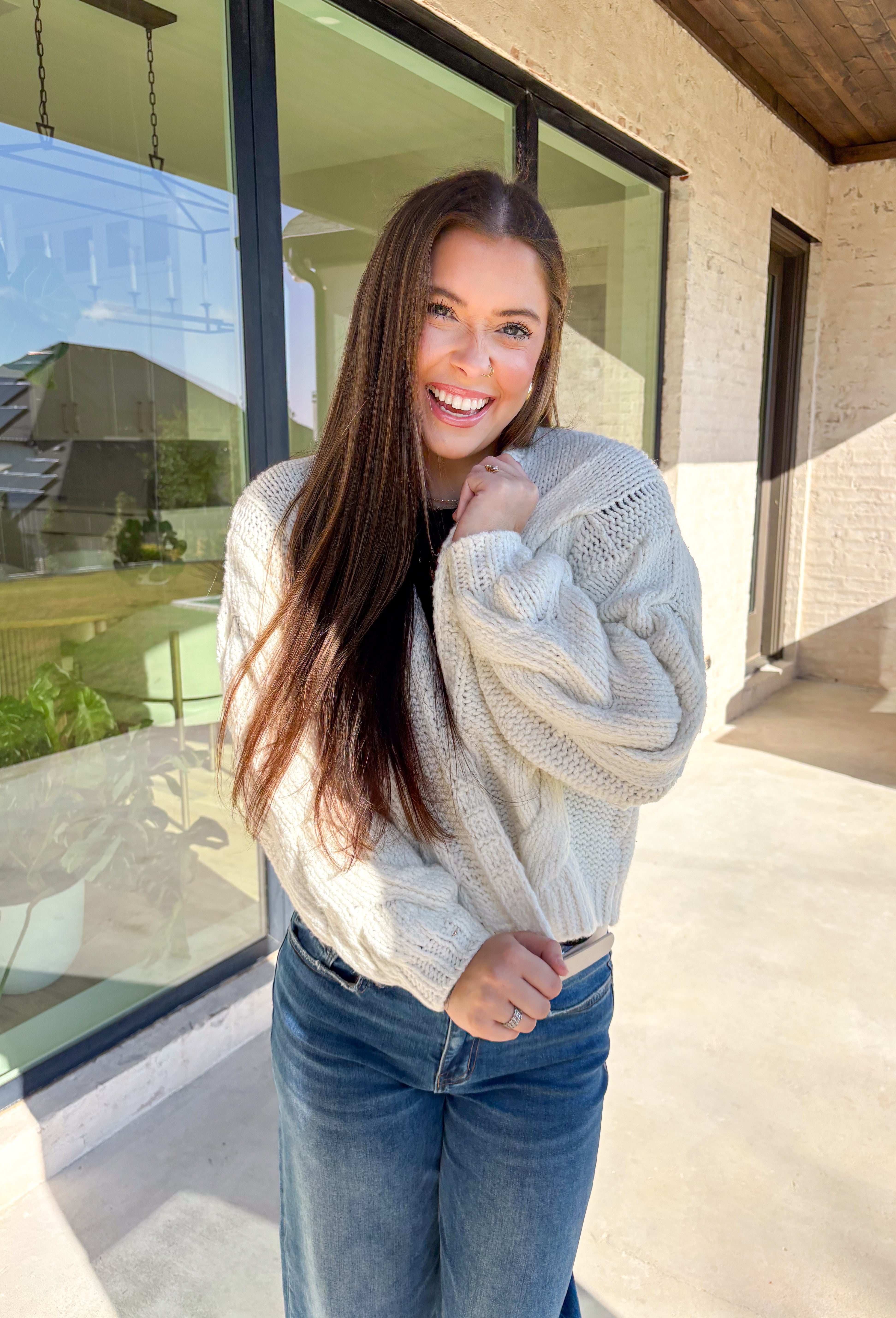 Cozy up in this off-white open-front cardigan by Double Zero. Designed with a chunky cable knit texture, this cardigan is the perfect layering piece for crisp fall days. The relaxed fit and soft feel make it a versatile staple you’ll reach for again and again—whether you’re styling it over a dress or pairing it with jeans and a tee.