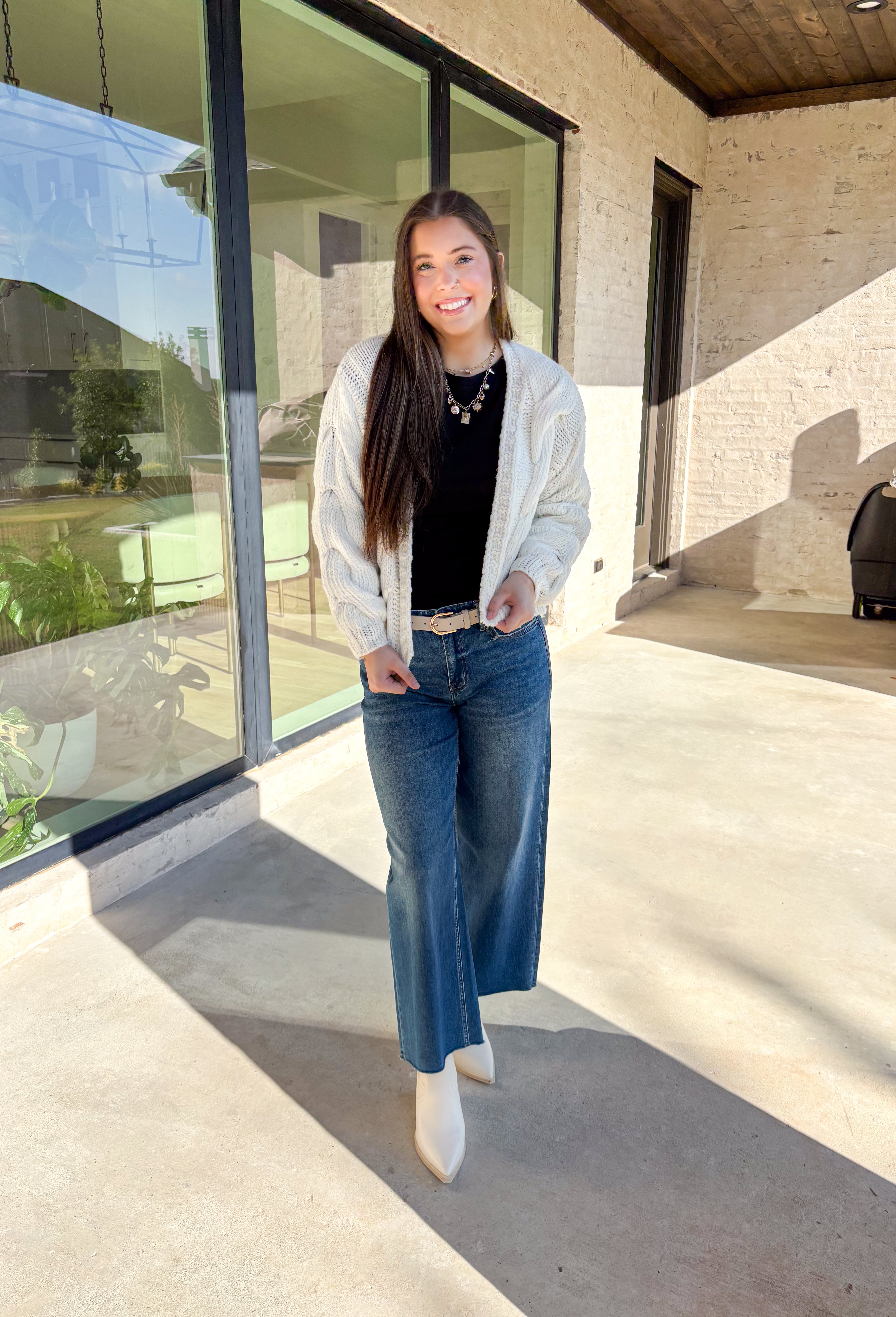 Cozy up in this off-white open-front cardigan by Double Zero. Designed with a chunky cable knit texture, this cardigan is the perfect layering piece for crisp fall days. The relaxed fit and soft feel make it a versatile staple you’ll reach for again and again—whether you’re styling it over a dress or pairing it with jeans and a tee.