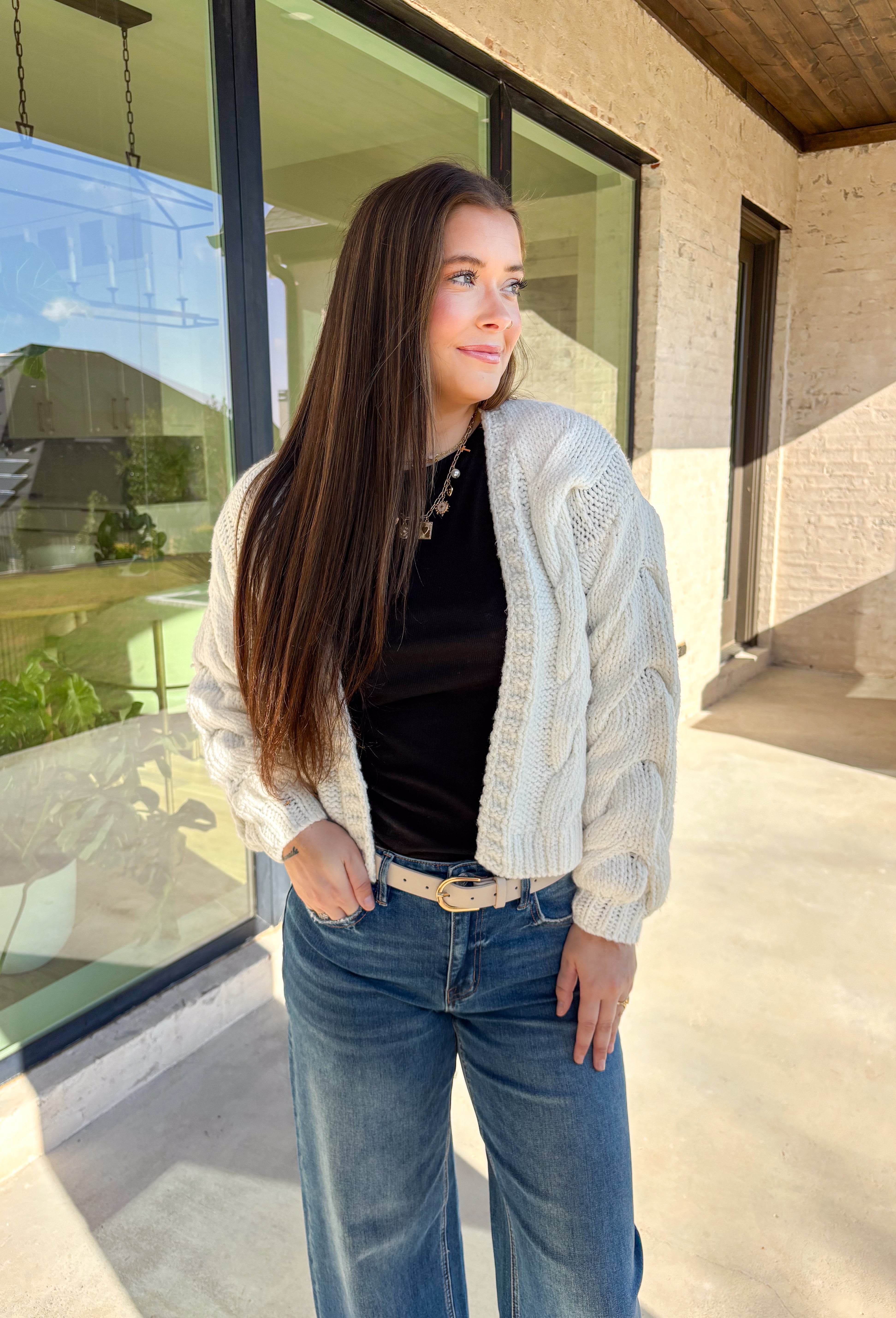 Cozy up in this off-white open-front cardigan by Double Zero. Designed with a chunky cable knit texture, this cardigan is the perfect layering piece for crisp fall days. The relaxed fit and soft feel make it a versatile staple you’ll reach for again and again—whether you’re styling it over a dress or pairing it with jeans and a tee.