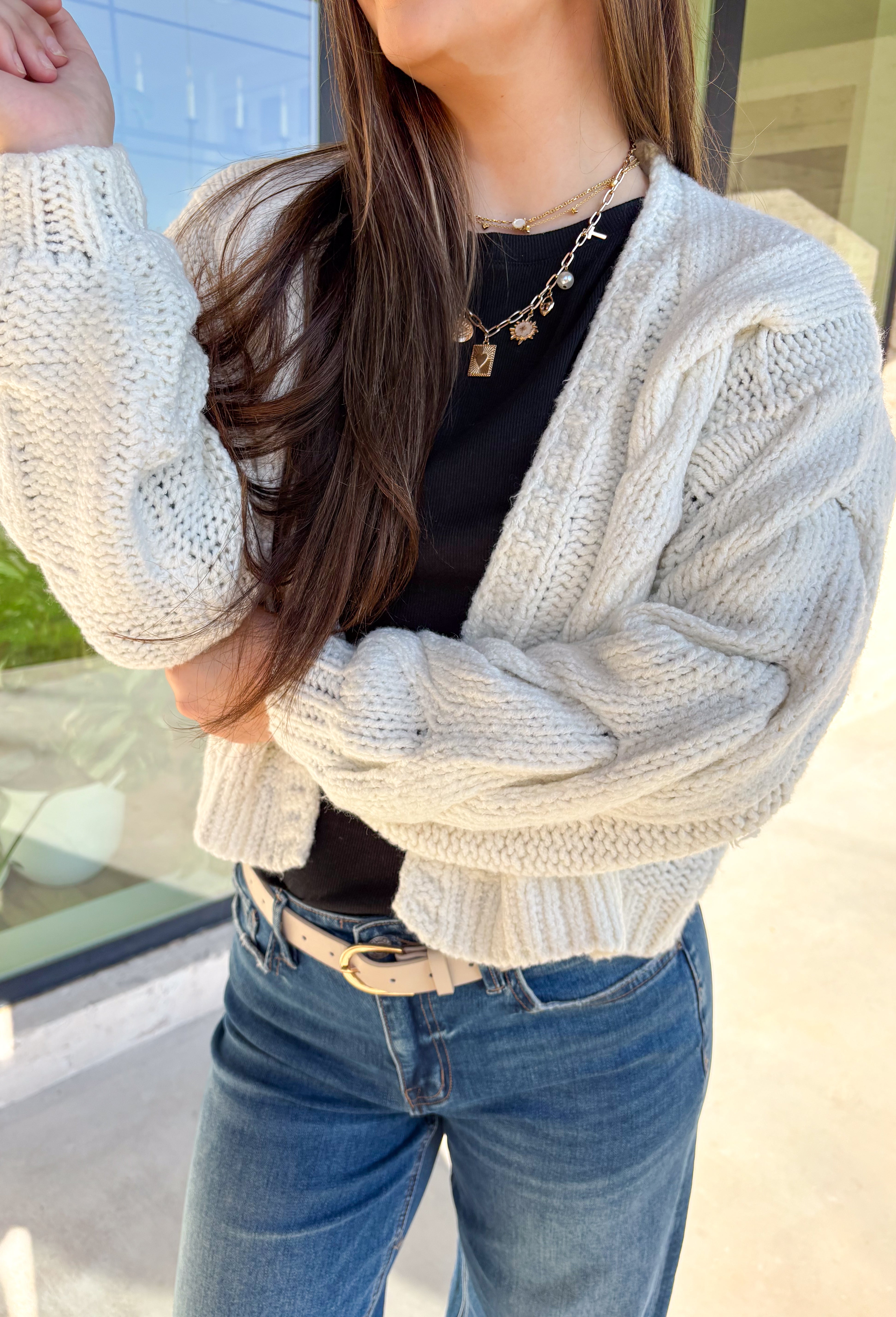 Cozy up in this off-white open-front cardigan by Double Zero. Designed with a chunky cable knit texture, this cardigan is the perfect layering piece for crisp fall days. The relaxed fit and soft feel make it a versatile staple you’ll reach for again and again—whether you’re styling it over a dress or pairing it with jeans and a tee.
