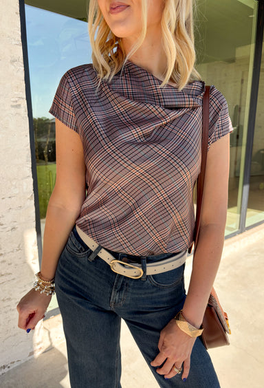 Add a fresh take on classic fall plaid to your wardrobe with this brown micro plaid top from Current Air. The draped cowl neckline creates a soft gathered effect that gives the silhouette a little extra interest without feeling overdone. A ribbed backing adds an unexpected mix of texture, while the warm brown plaid makes it easy to pair with all your favorite autumn neutrals. Wear it with trousers for a put-together office look, then swap in denim and boots when the weekend rolls around.