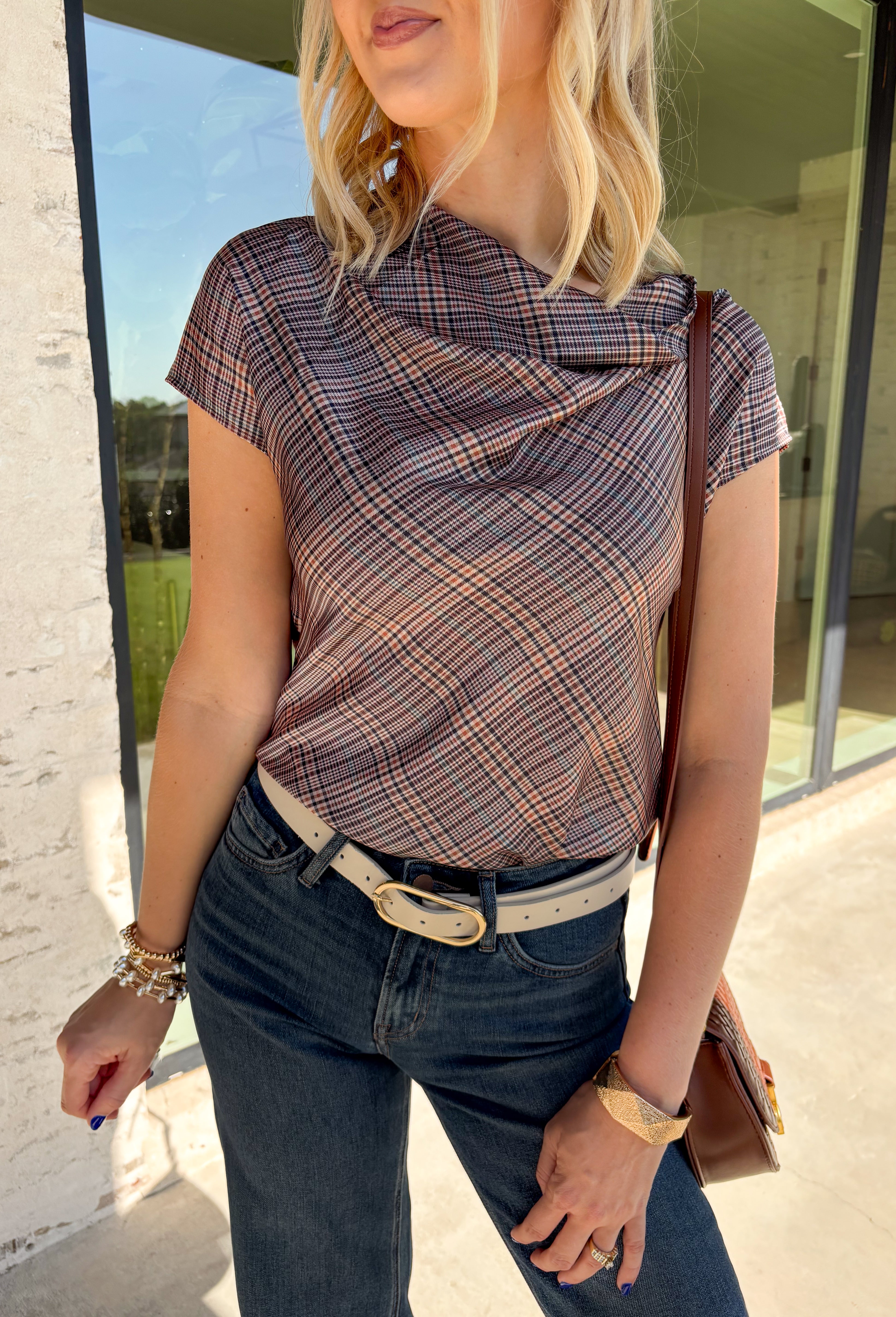 Add a fresh take on classic fall plaid to your wardrobe with this brown micro plaid top from Current Air. The draped cowl neckline creates a soft gathered effect that gives the silhouette a little extra interest without feeling overdone. A ribbed backing adds an unexpected mix of texture, while the warm brown plaid makes it easy to pair with all your favorite autumn neutrals. Wear it with trousers for a put-together office look, then swap in denim and boots when the weekend rolls around.