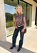 Add a fresh take on classic fall plaid to your wardrobe with this brown micro plaid top from Current Air. The draped cowl neckline creates a soft gathered effect that gives the silhouette a little extra interest without feeling overdone. A ribbed backing adds an unexpected mix of texture, while the warm brown plaid makes it easy to pair with all your favorite autumn neutrals. Wear it with trousers for a put-together office look, then swap in denim and boots when the weekend rolls around.