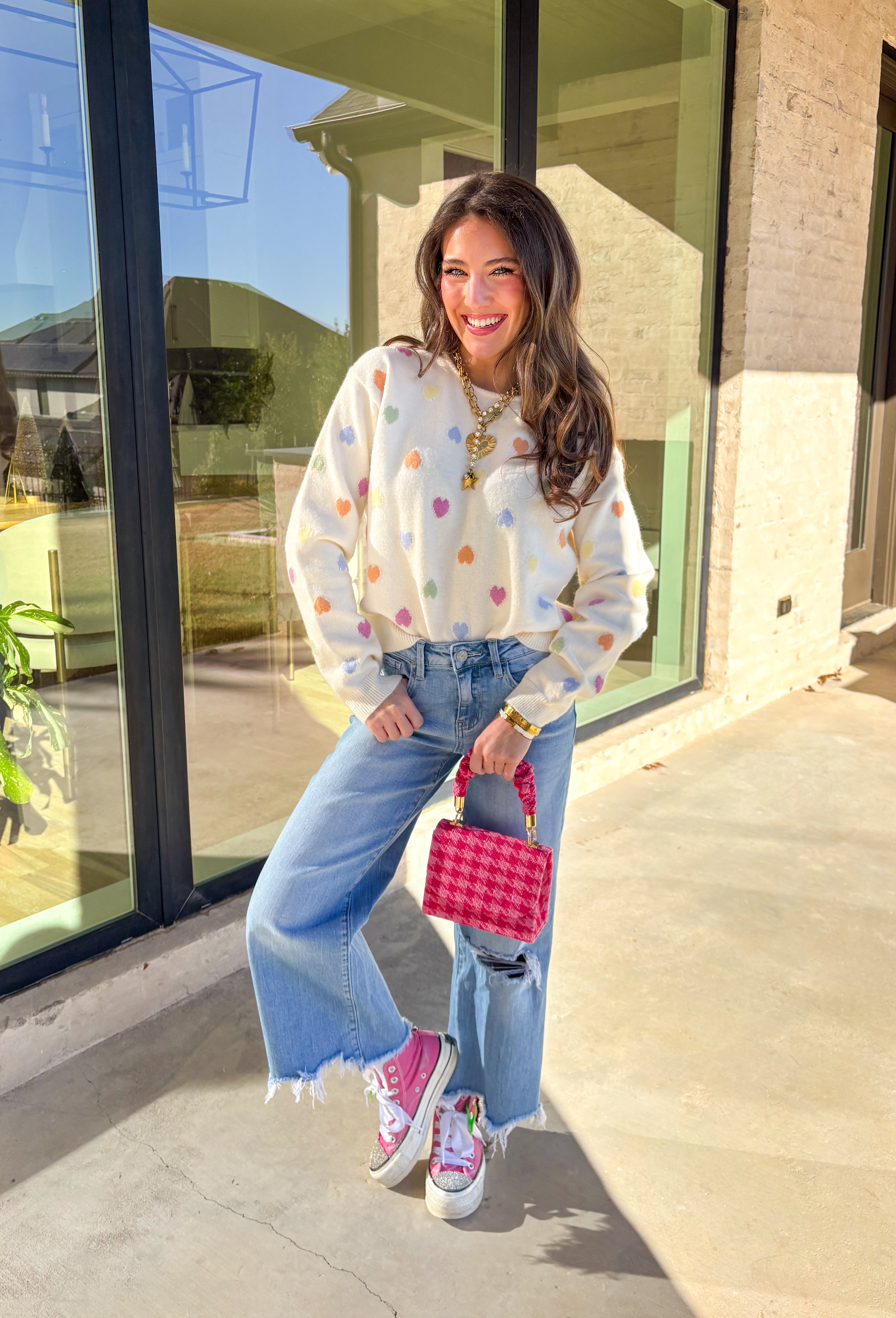 Sweet, cheerful, and full of love, this cream sweater by Sunday Edition is perfect for Valentine’s Day and beyond. Featuring a colorful heart print in shades of orange, pink, yellow, green, and blue, this cozy knit brings a fun pop of color to your wardrobe. Soft and lightweight with an easy fit, it’s the kind of sweater that feels festive for February but still cute all season long.