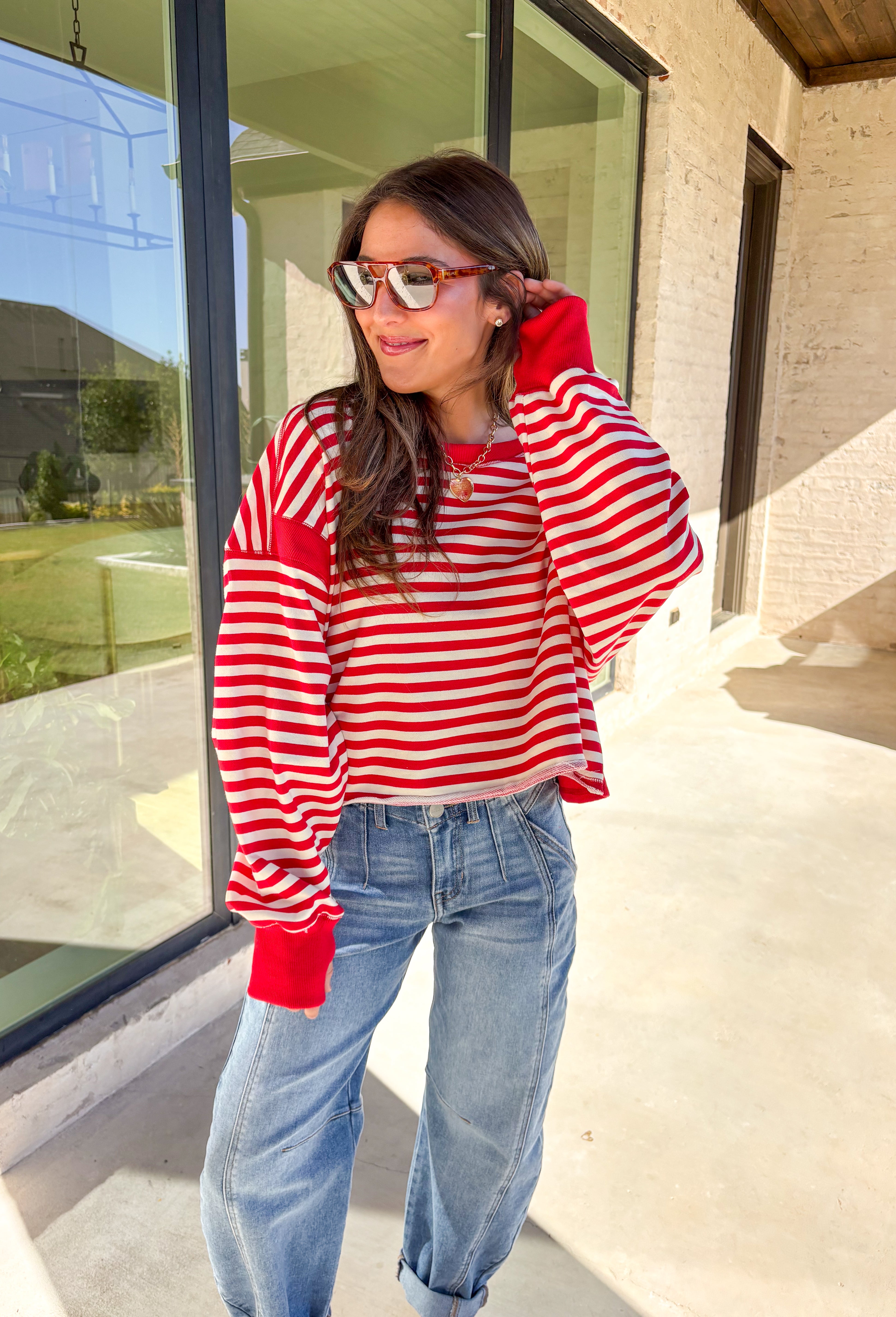 A classic stripe with a flirty twist—this red and ivory long sleeve top by Rae Mode is perfect for cozy yet stylish days. The open-back design adds a fun surprise, while the solid red detailing on the cuffs, sleeve centers, and neckline gives it a bold pop. Crafted from a soft, stretchy fabric blend, it’s the ultimate mix of comfort and statement style for the season.