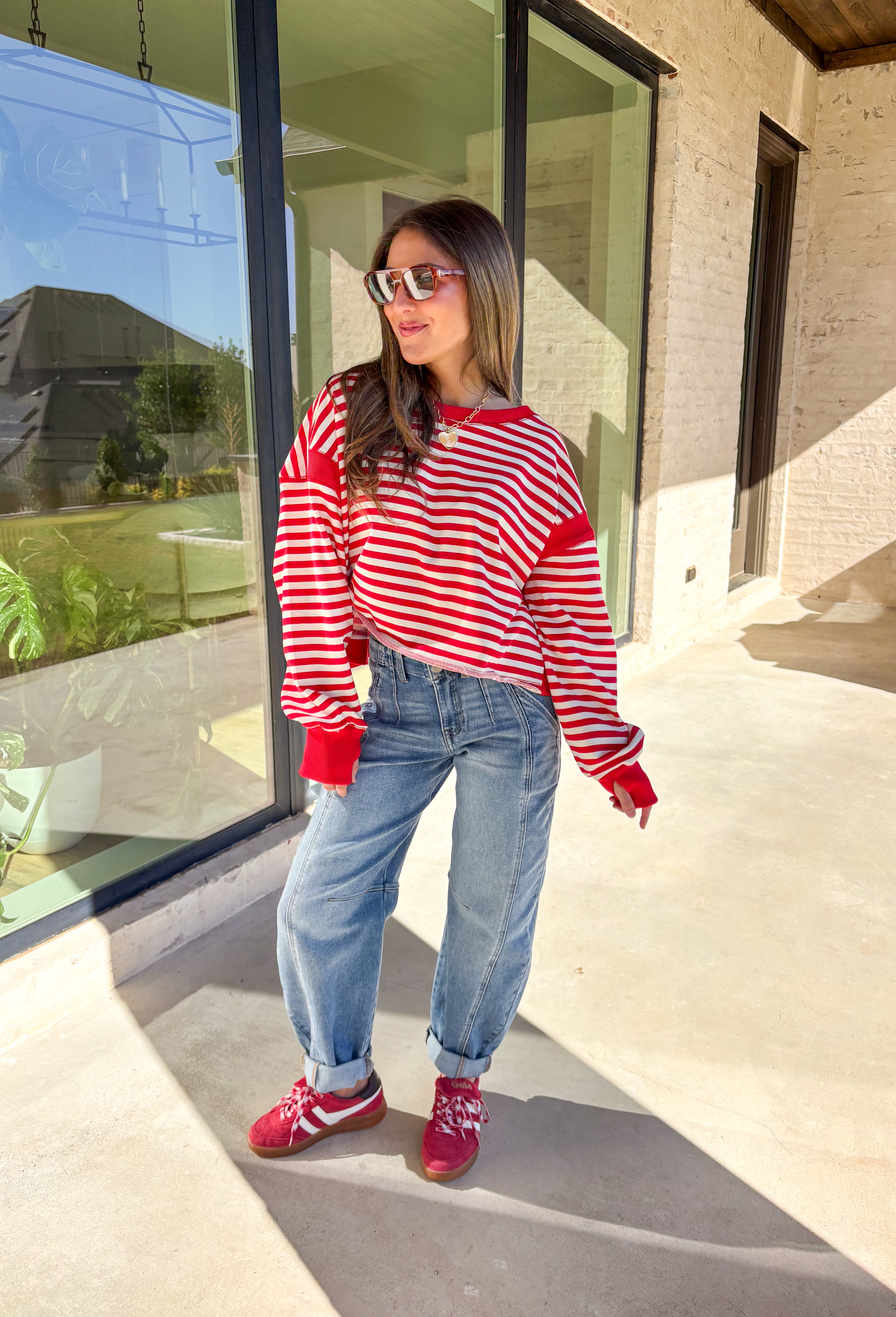 A classic stripe with a flirty twist—this red and ivory long sleeve top by Rae Mode is perfect for cozy yet stylish days. The open-back design adds a fun surprise, while the solid red detailing on the cuffs, sleeve centers, and neckline gives it a bold pop. Crafted from a soft, stretchy fabric blend, it’s the ultimate mix of comfort and statement style for the season.