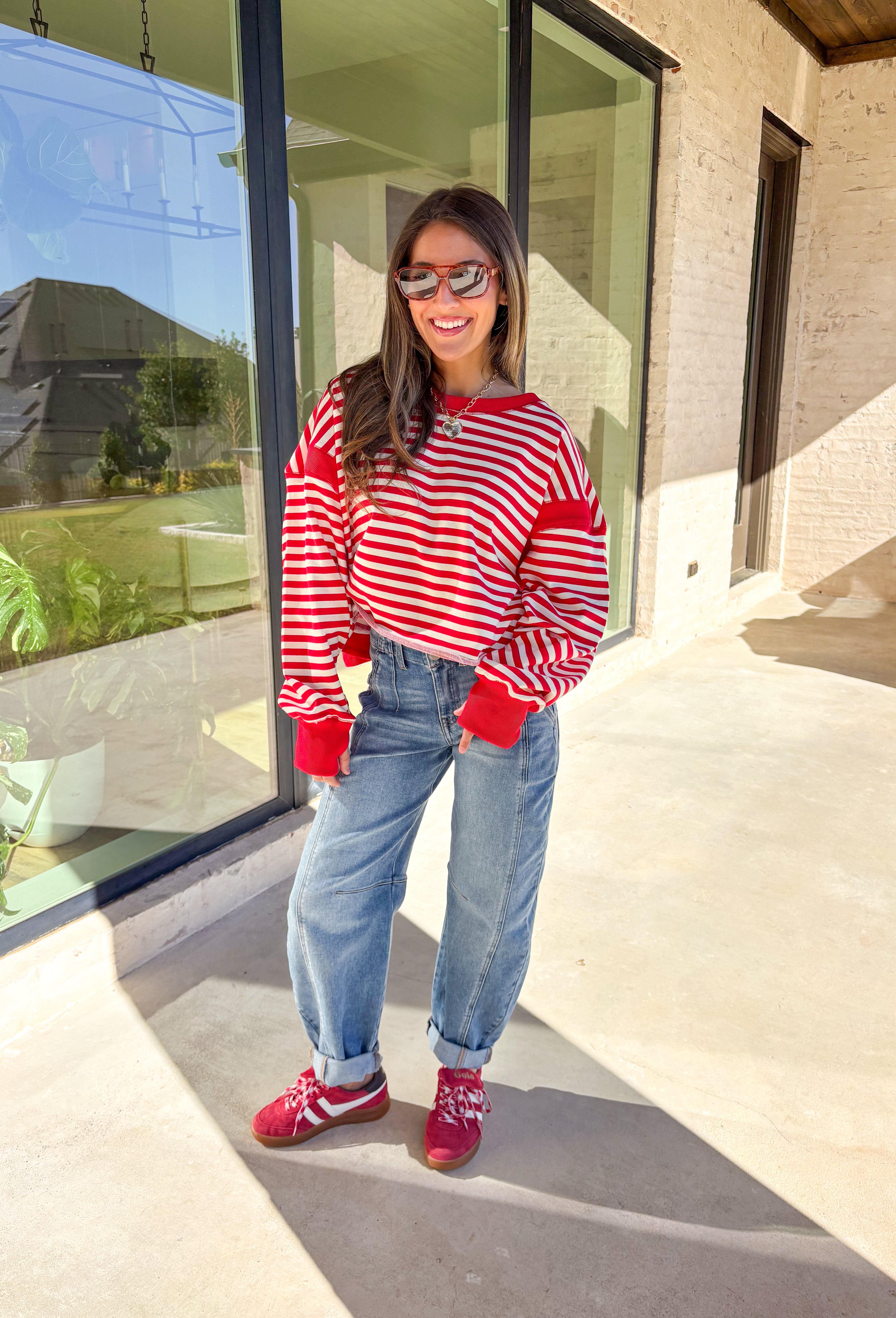 A classic stripe with a flirty twist—this red and ivory long sleeve top by Rae Mode is perfect for cozy yet stylish days. The open-back design adds a fun surprise, while the solid red detailing on the cuffs, sleeve centers, and neckline gives it a bold pop. Crafted from a soft, stretchy fabric blend, it’s the ultimate mix of comfort and statement style for the season.