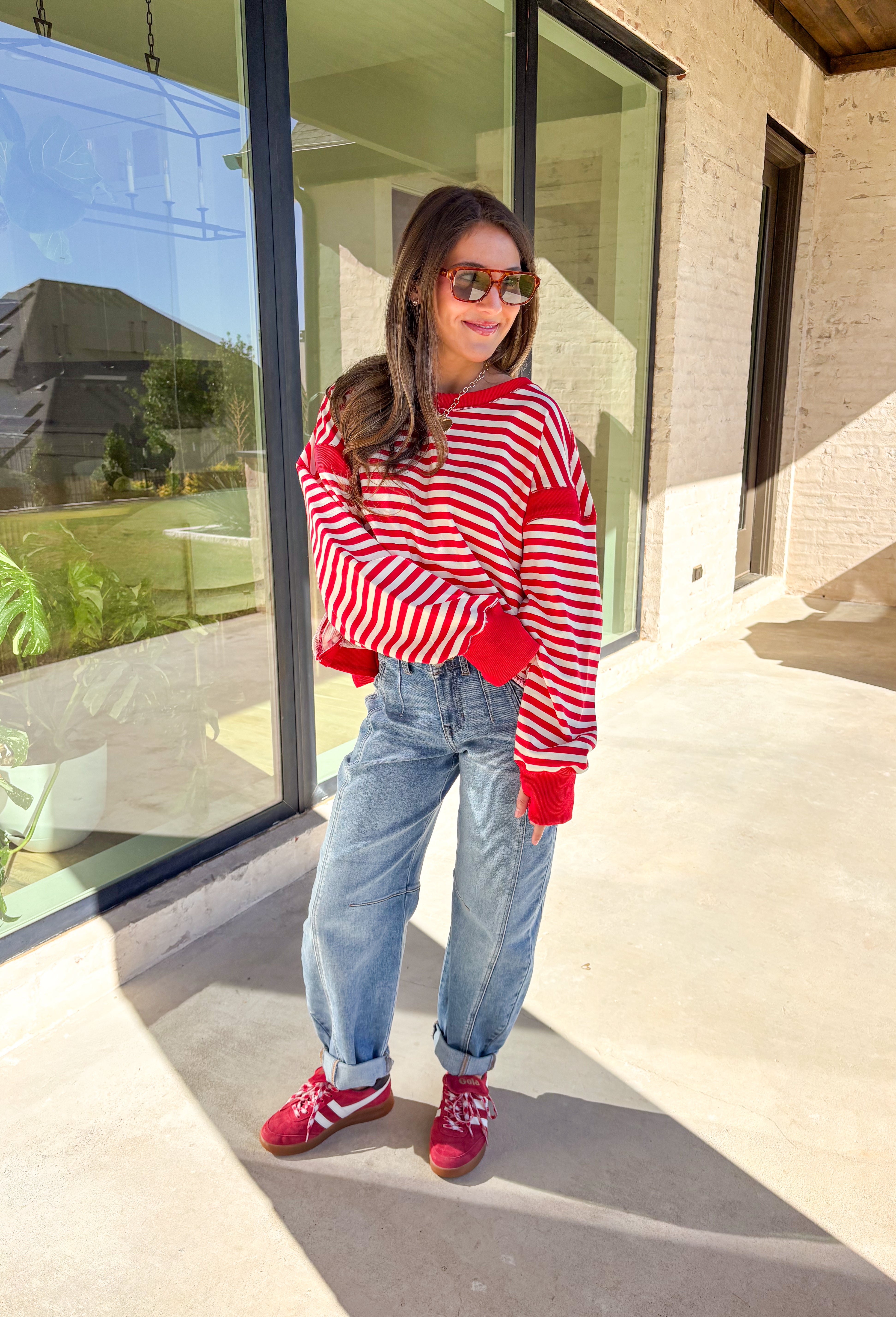 A classic stripe with a flirty twist—this red and ivory long sleeve top by Rae Mode is perfect for cozy yet stylish days. The open-back design adds a fun surprise, while the solid red detailing on the cuffs, sleeve centers, and neckline gives it a bold pop. Crafted from a soft, stretchy fabric blend, it’s the ultimate mix of comfort and statement style for the season.