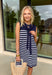 Polished with a playful twist! This navy sleeveless dress features a timeless white stripe print and a unique knit scarf tie detail at the neckline that instantly elevates the look. It’s classic, but with just enough personality to stand out. The sleeveless silhouette keeps it sleek and versatile, while the soft knit fabric offers a comfortable, flattering drape. Whether you’re heading to brunch, the office, or a weekend getaway, this dress makes getting dressed feel effortless and put-together.