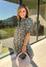 Embrace the beauty of the season in this charming dress from Entro. Featuring a gorgeous floral print in shades of hunter green, muted green, peach, and brown, this feminine dress is perfect for everything from weekend brunches to seasonal celebrations. The button-front design and flattering neckline create a timeless silhouette, while the ¾ puff sleeves with delicate tie details add a playful touch. 